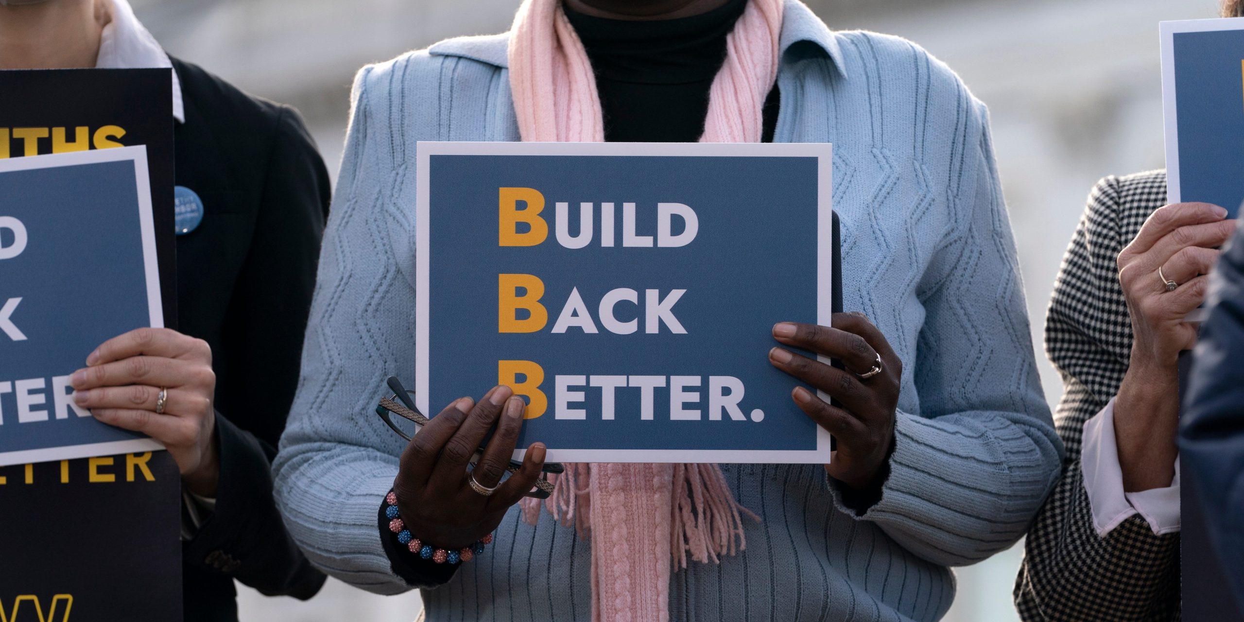 People hold signs that say Build Back Better.