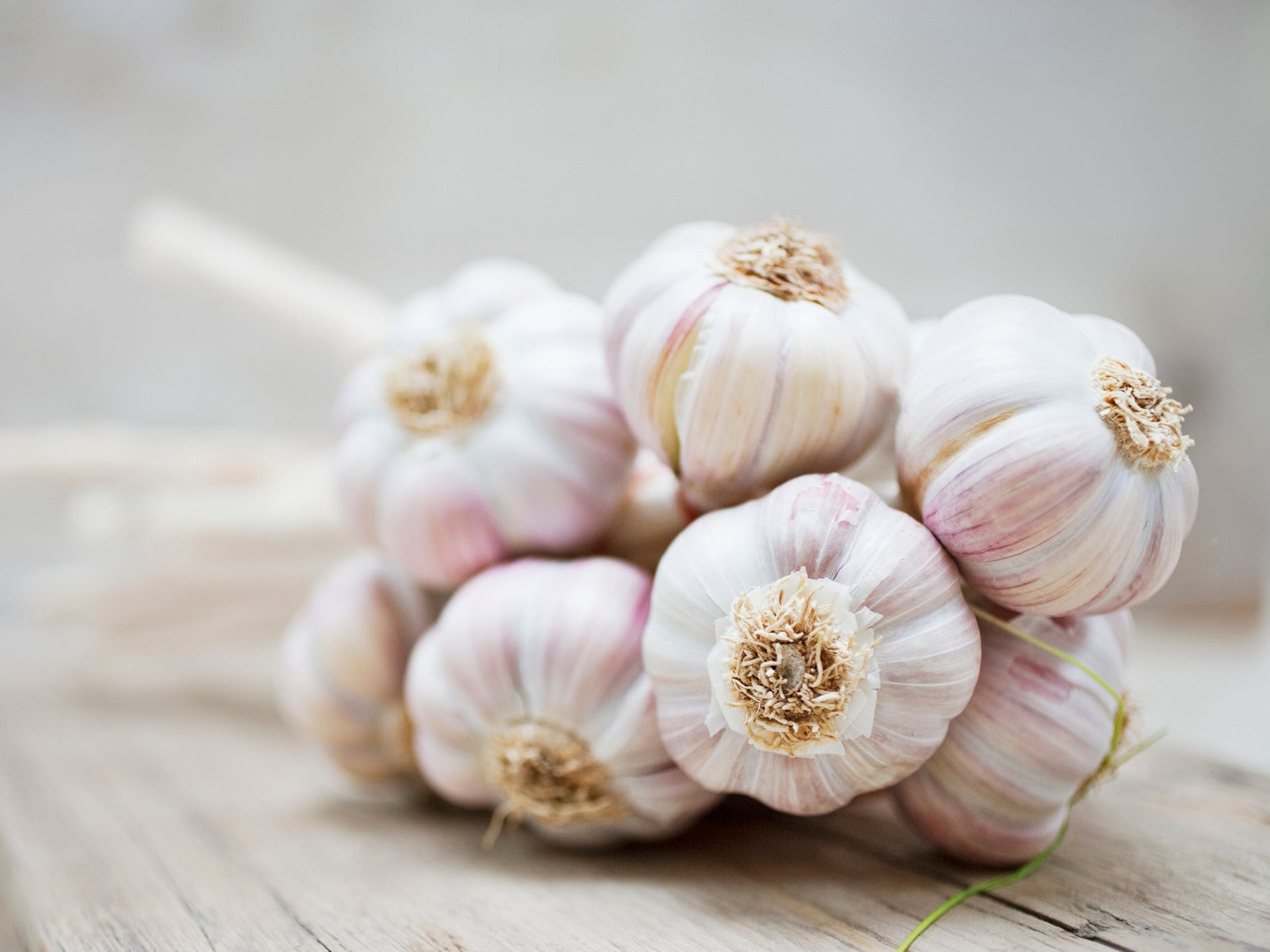 A bunch of garlic bulbs on a wood cutting board.