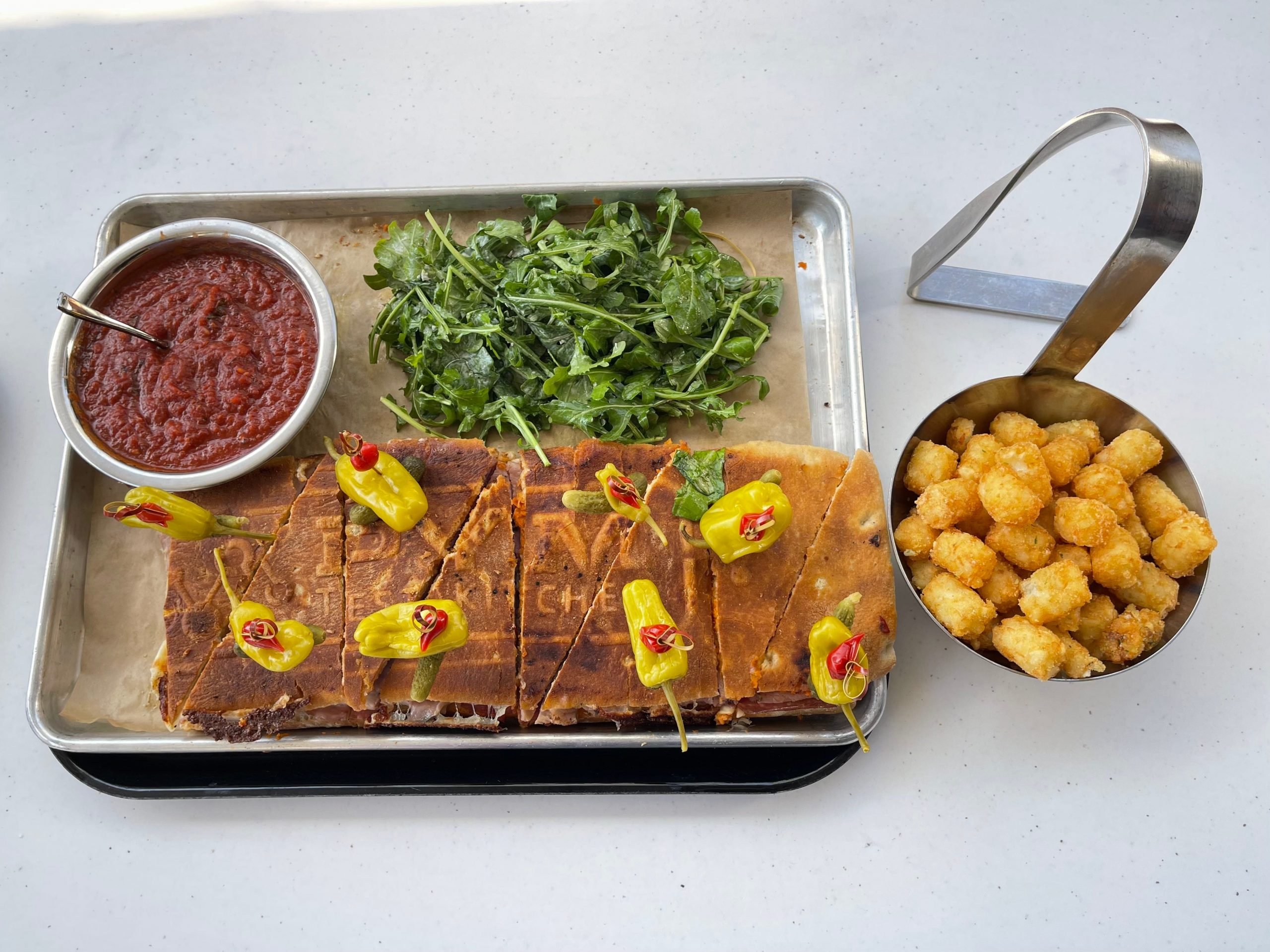 pym panini at disneyland with tater tots, salad, and marinara sauce