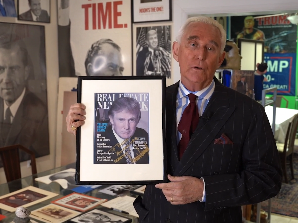 Roger Stone holds up an autographed print of former President Donald Trump.