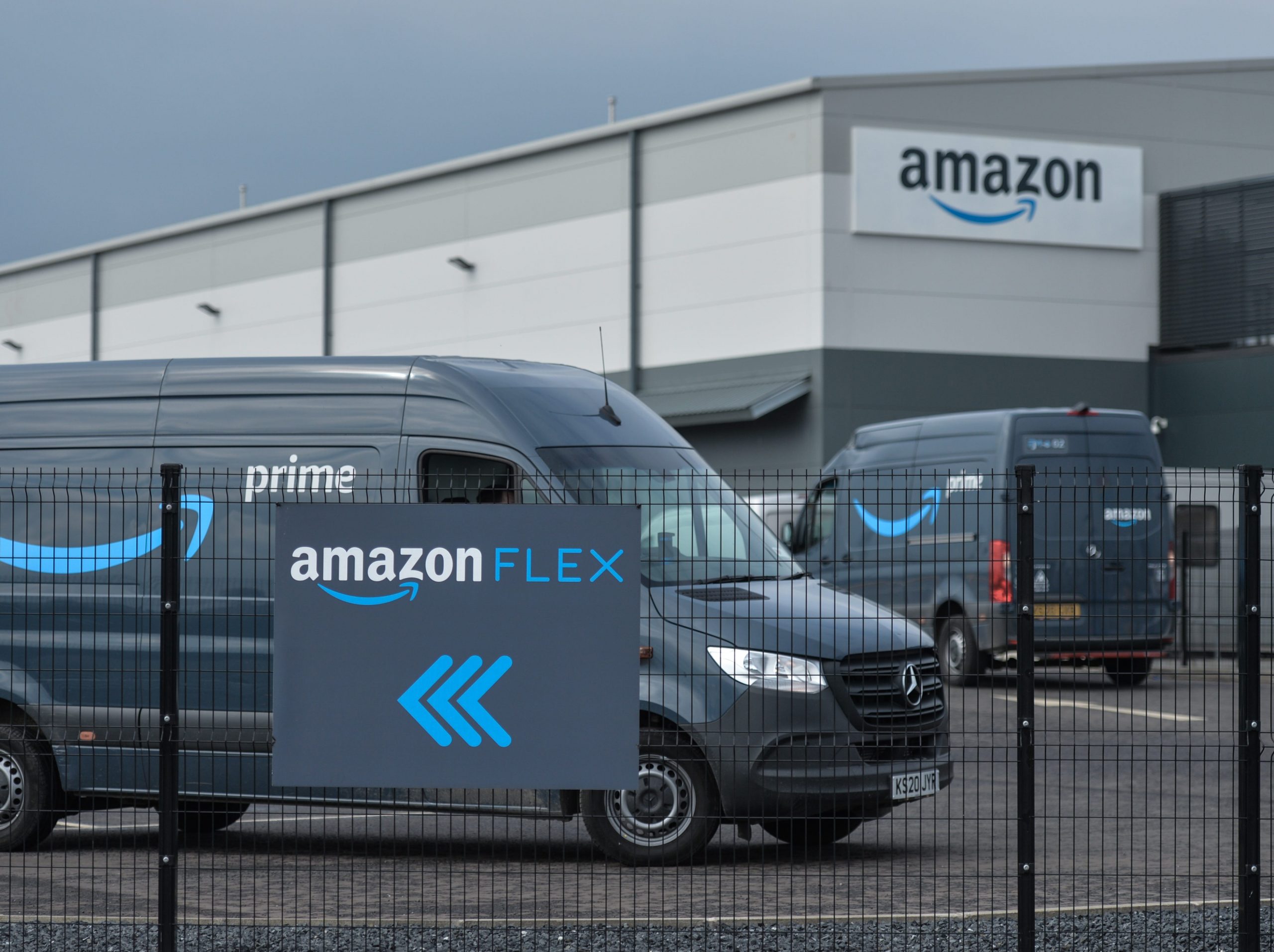 An Amazon Flex sign is shown with vehicles behind.