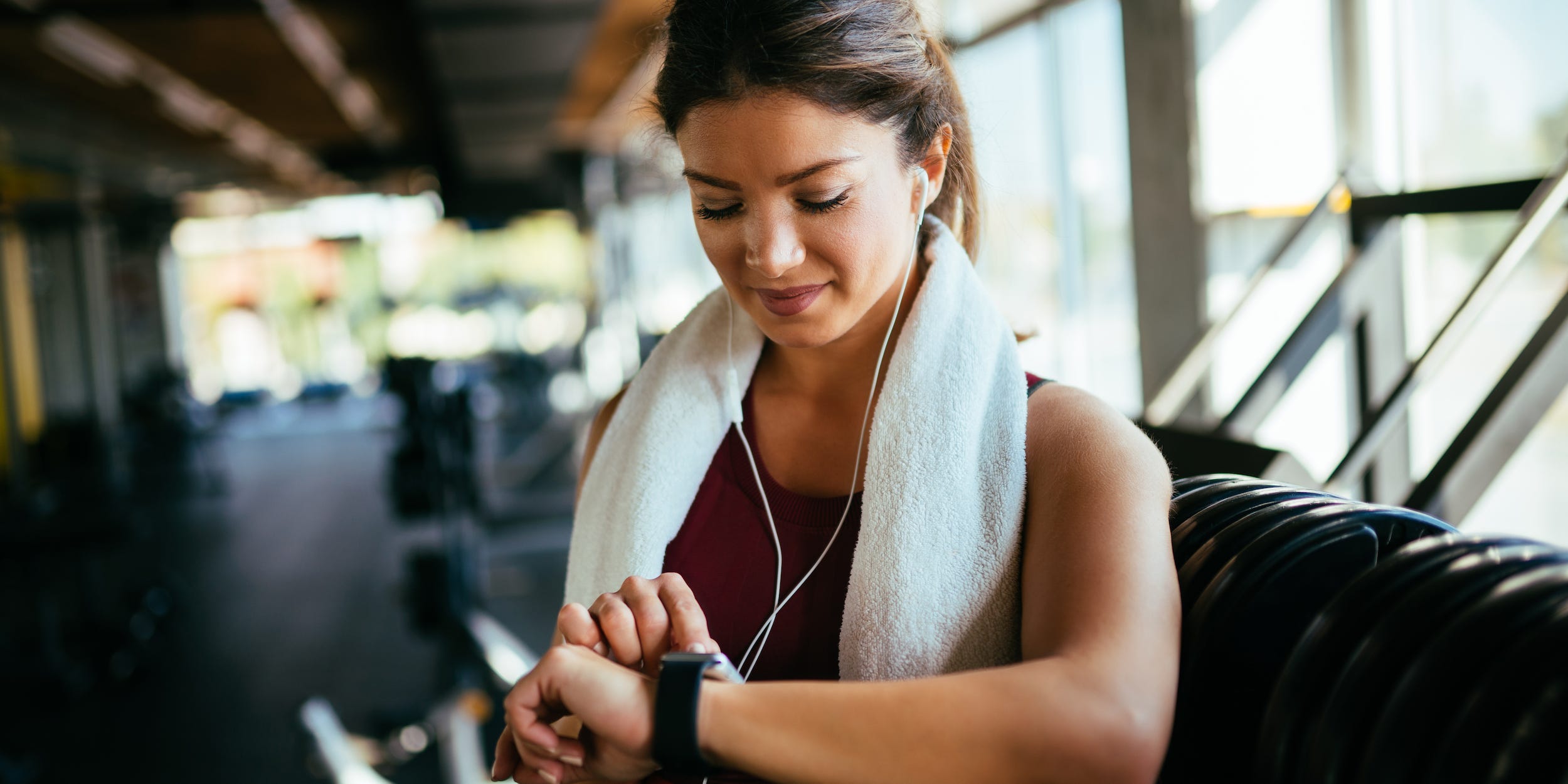 woman exercising in gym looking at smart watch