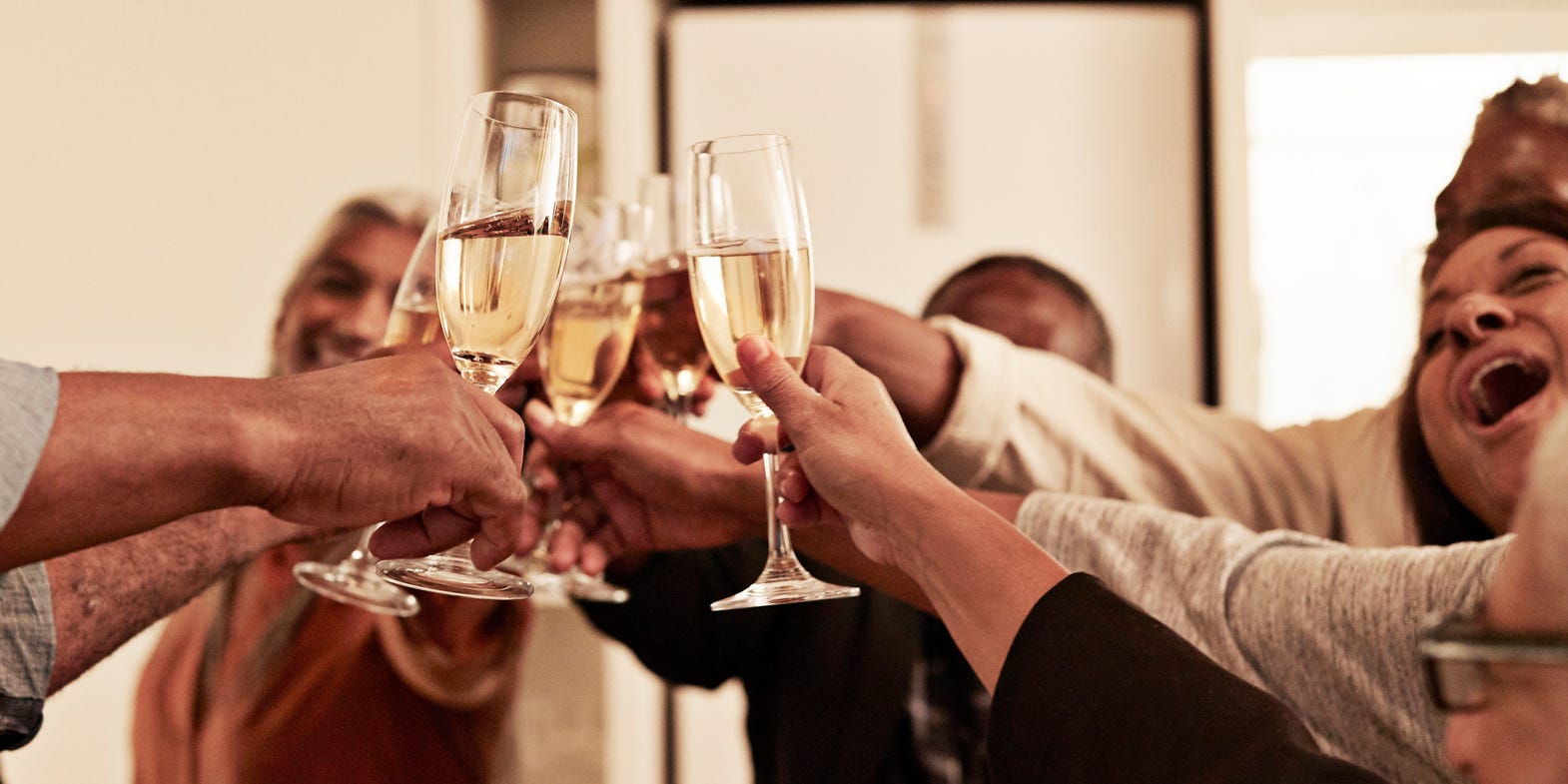 A group of friends toasts with glasses of Champagne
