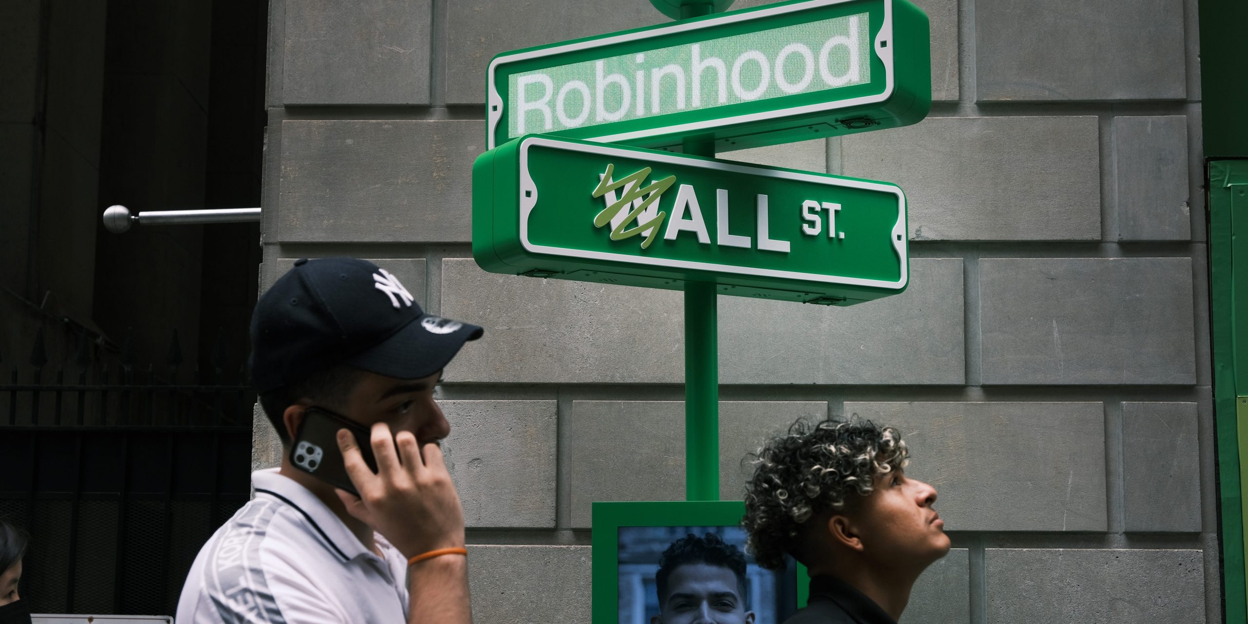 People wait in line for t-shirts at a pop-up kiosk for the online brokerage Robinhood along Wall Street after the company went public with an IPO earlier in the day on July 29, 2021 in New York City.