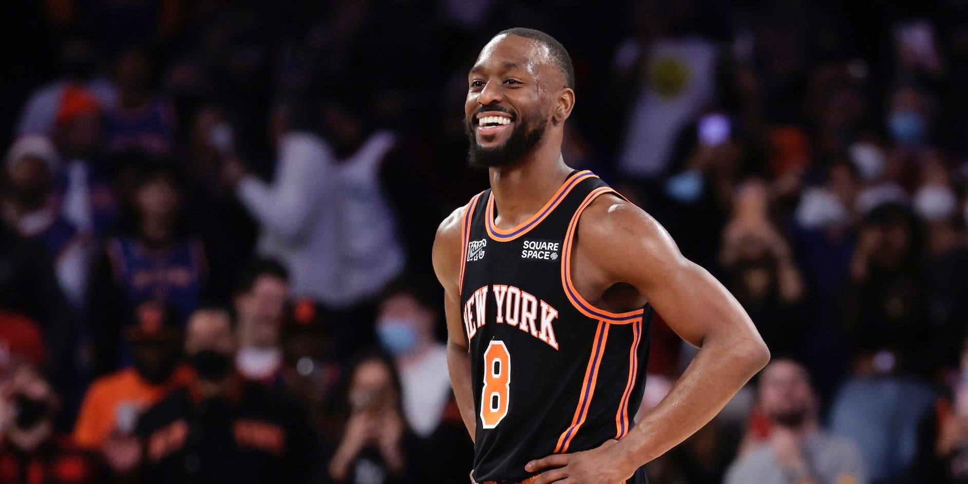 Kemba Walker stands with his hands on his hips and smiles.
