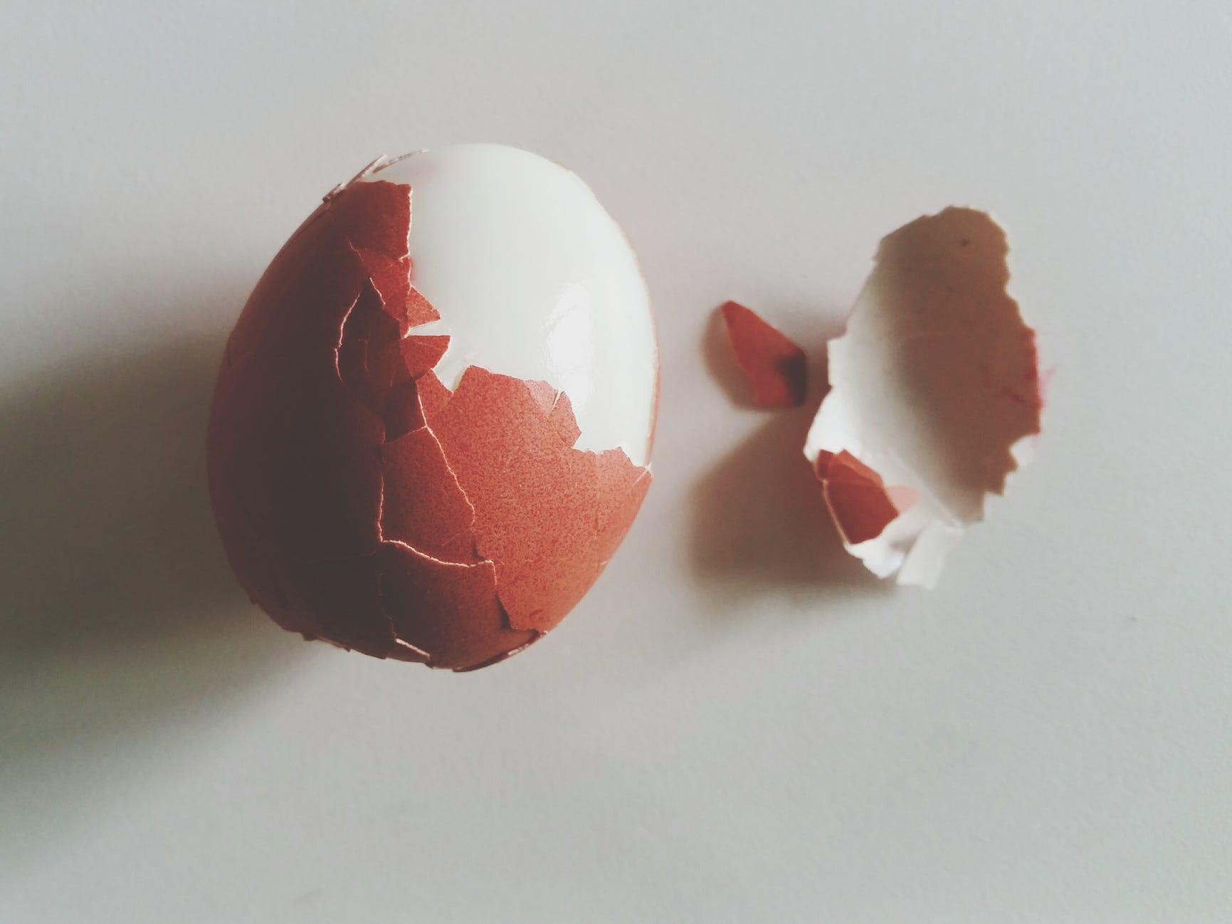 Overhead shot of a boiled egg with a cracked shell.