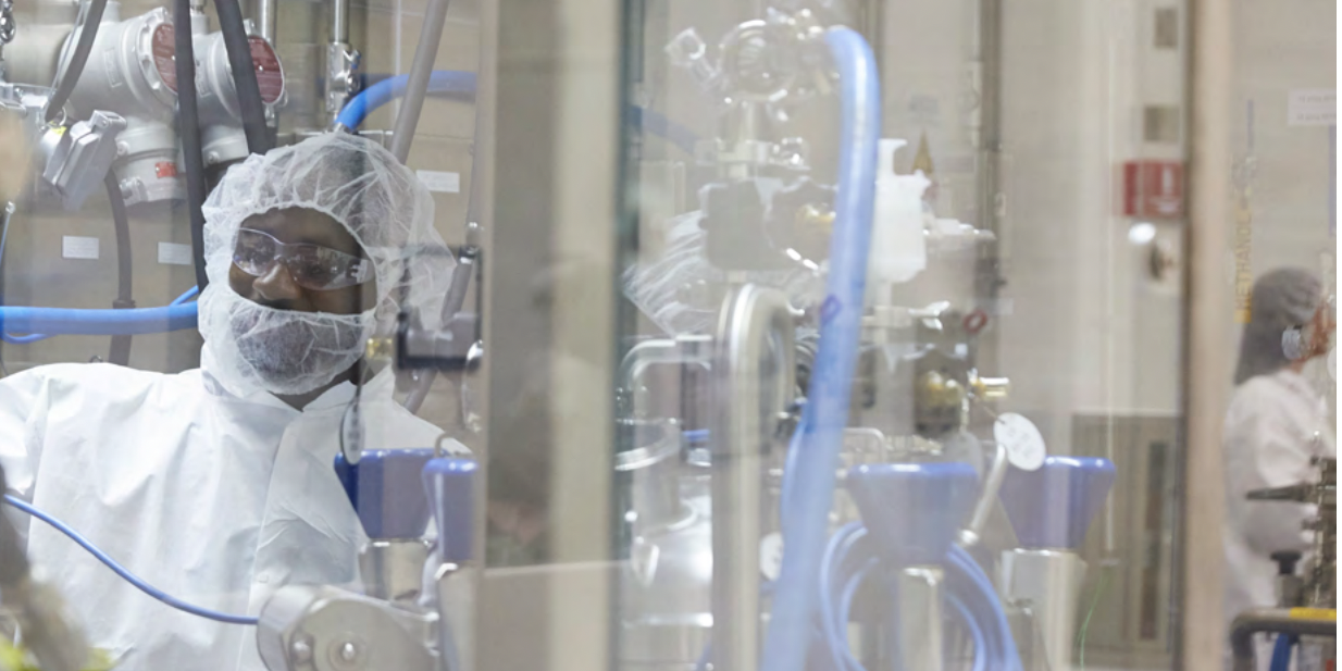 A worker in protective clothing works at a Biogen laboratory