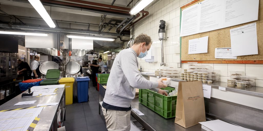 Medewerkers van Hotel New York treffen voorbereidingen voor het inpakken van dinerboxen.