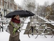 Wandelaars in het winterse centrum van Utrecht. Veel mensen gaan eropuit om te genieten van het dikke pak sneeuw.