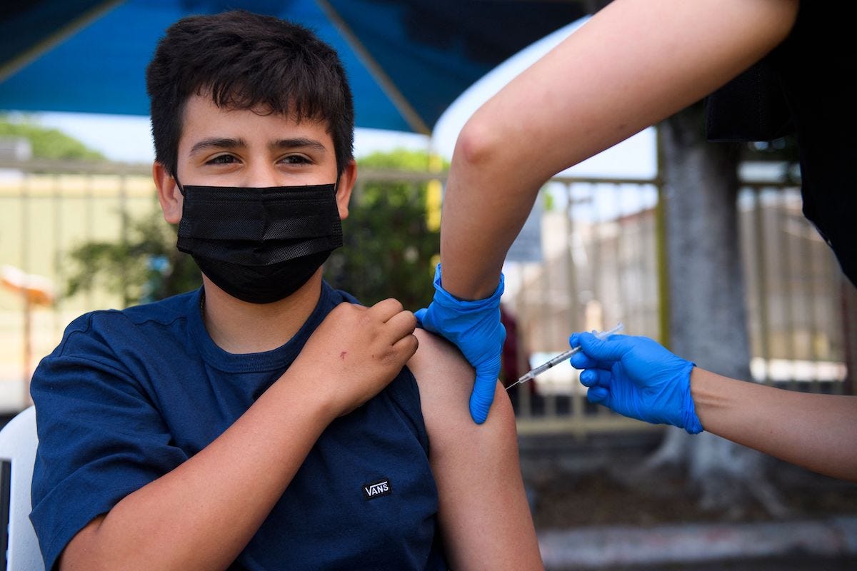 a teenager gets jabbed with a covid-19 vaccine