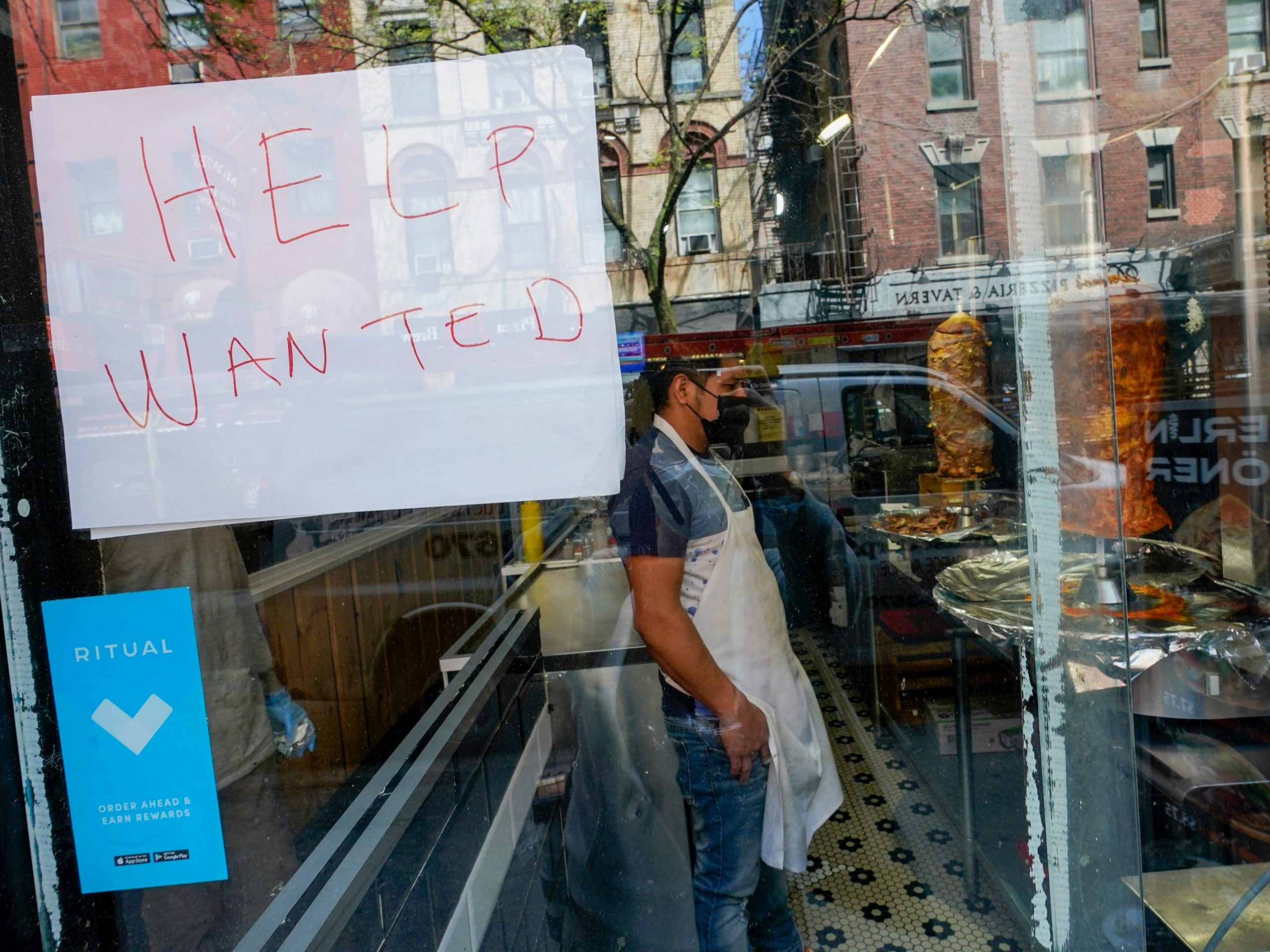 a help wanted sign at a storefront in New York