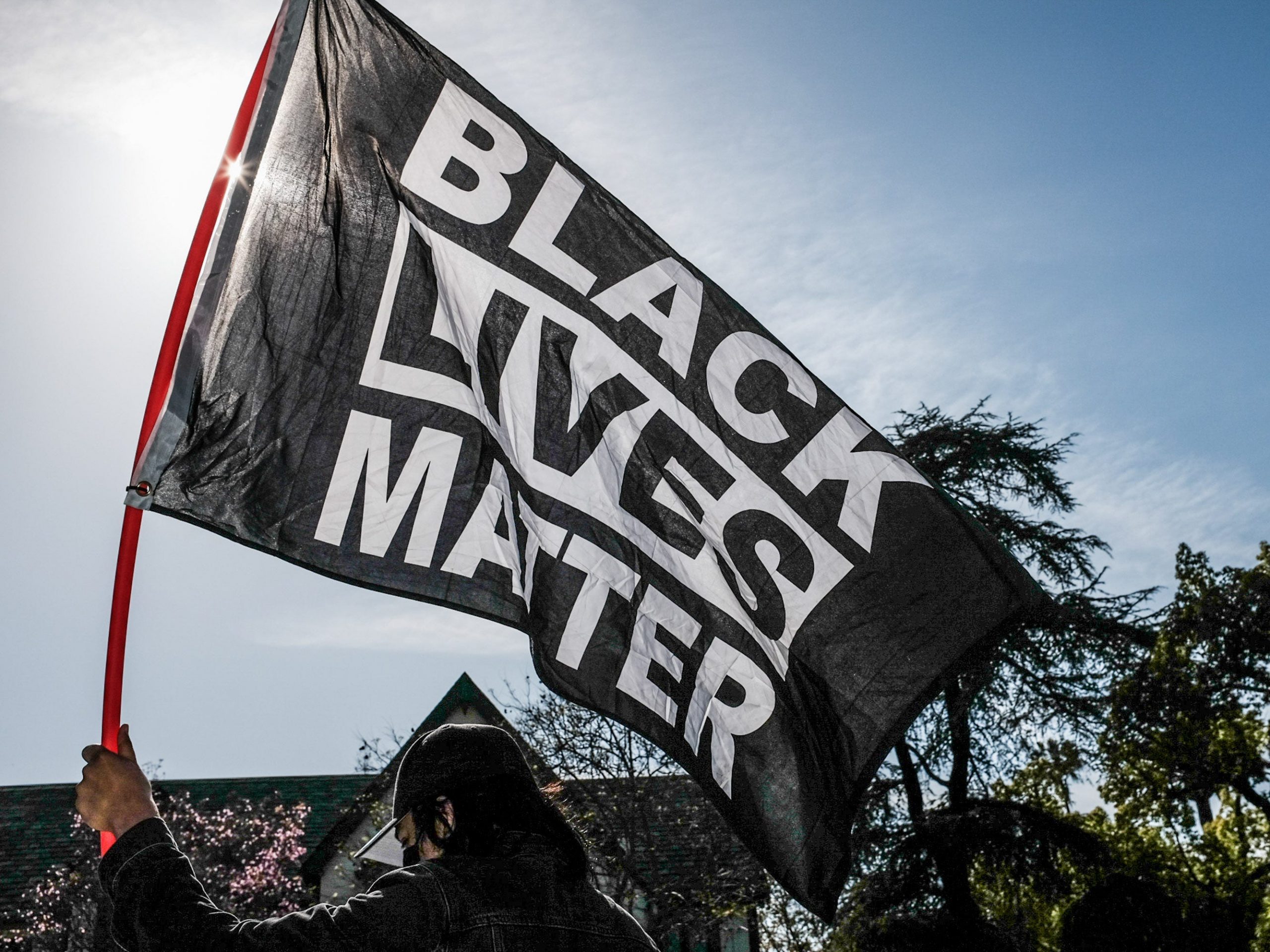 Someone waves a Black Lives Matter flag.
