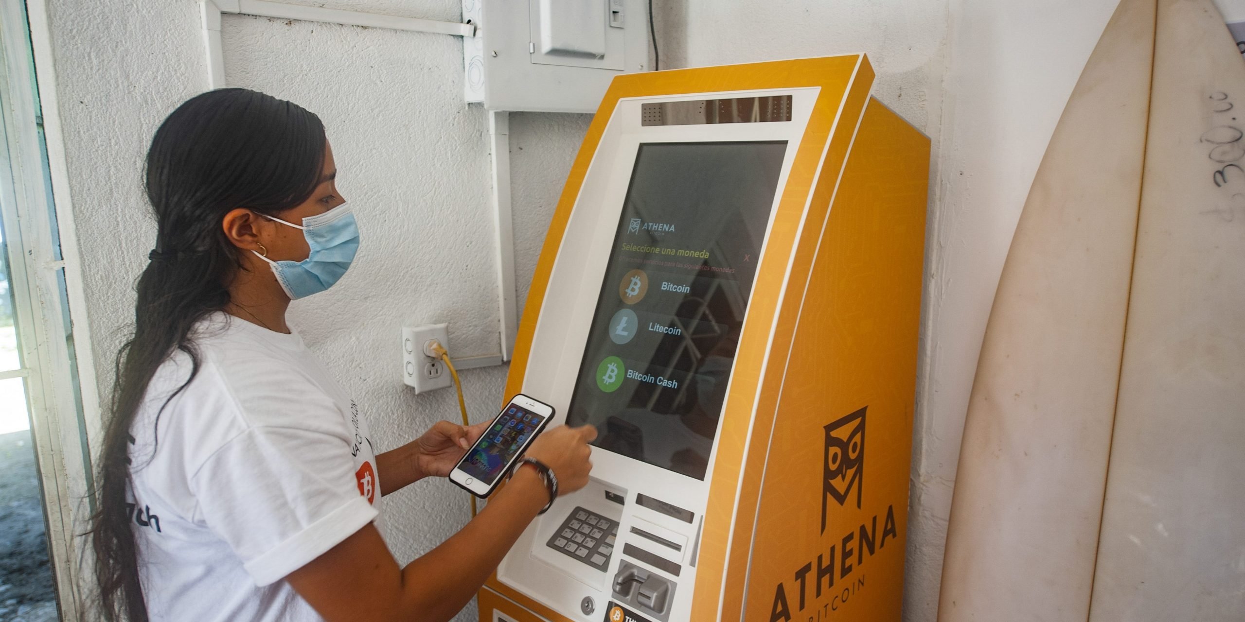 A woman withdraws money from a bitcoin ATM in El Salvador.