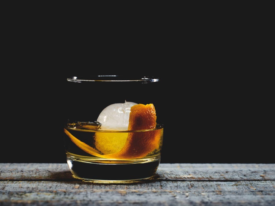 An old fashioned cocktail with round ice.
