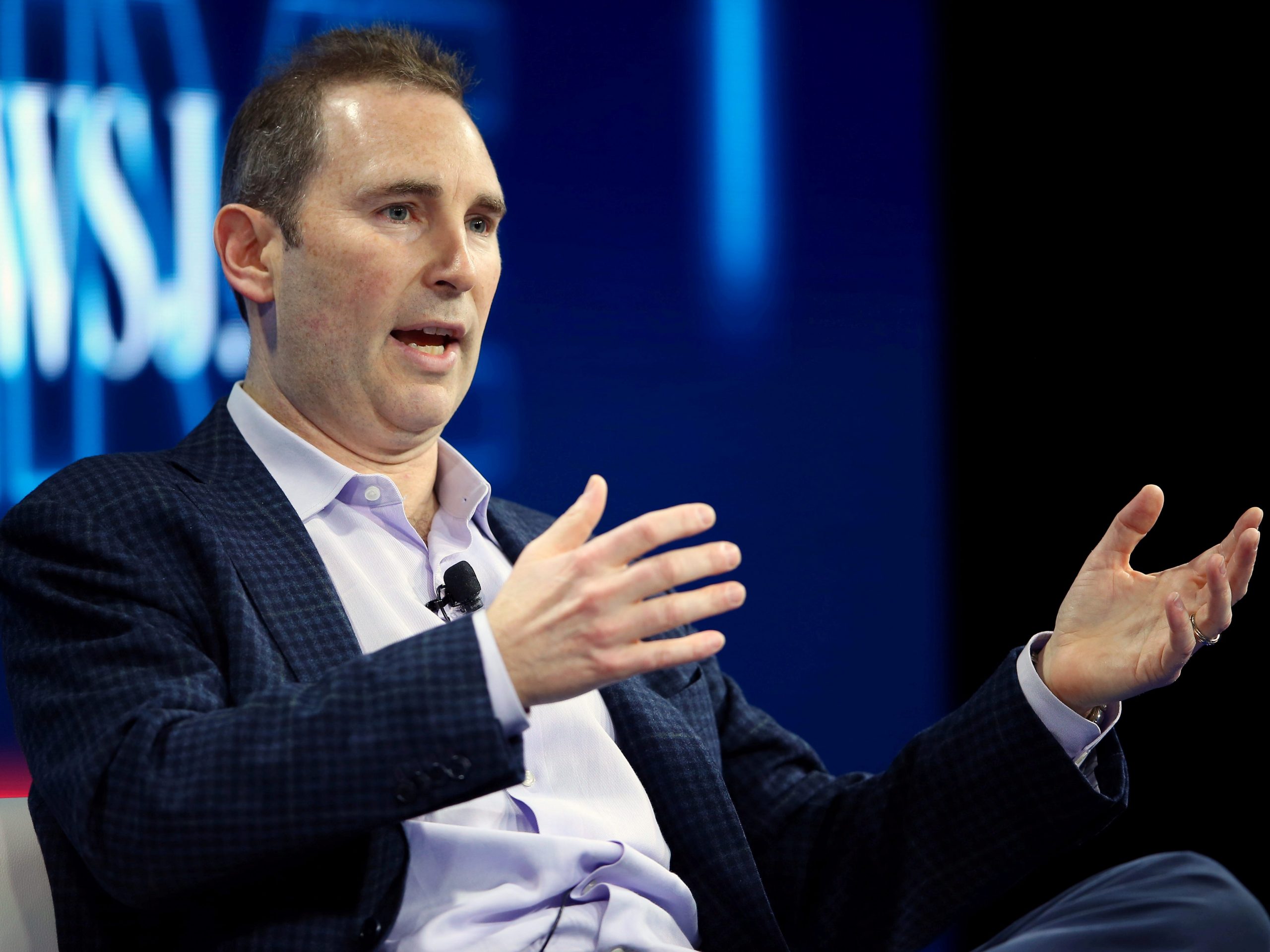 Amazon CEO Andy Jassy motions with his hands on stage at a conference.