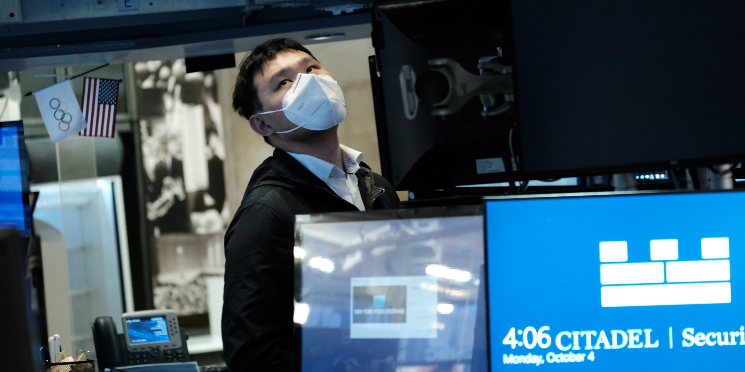 A trader wearing a mask works on the floor of the New York Stock Exchange