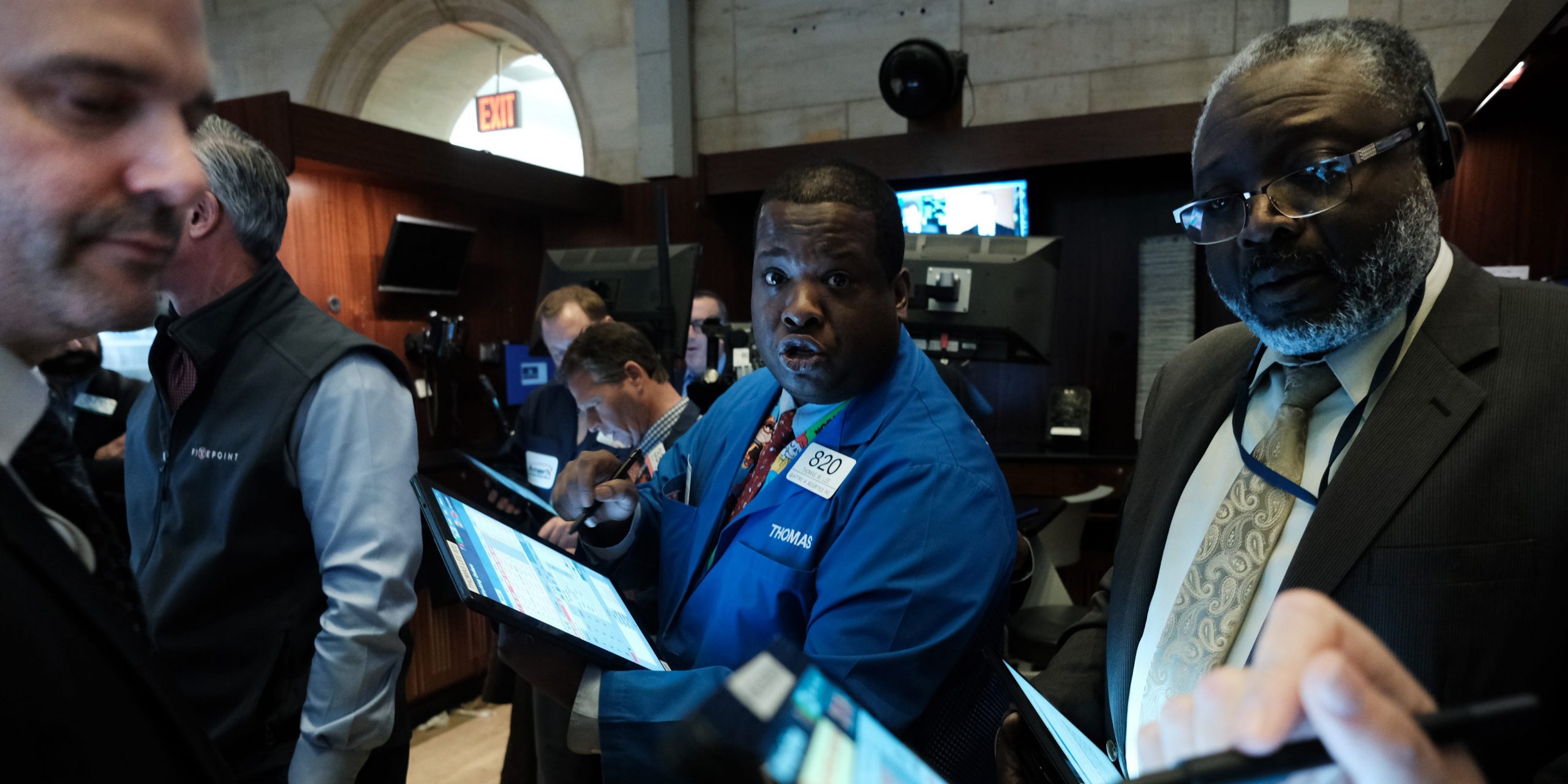 Three traders work on the floor of the New York Stock Exchange