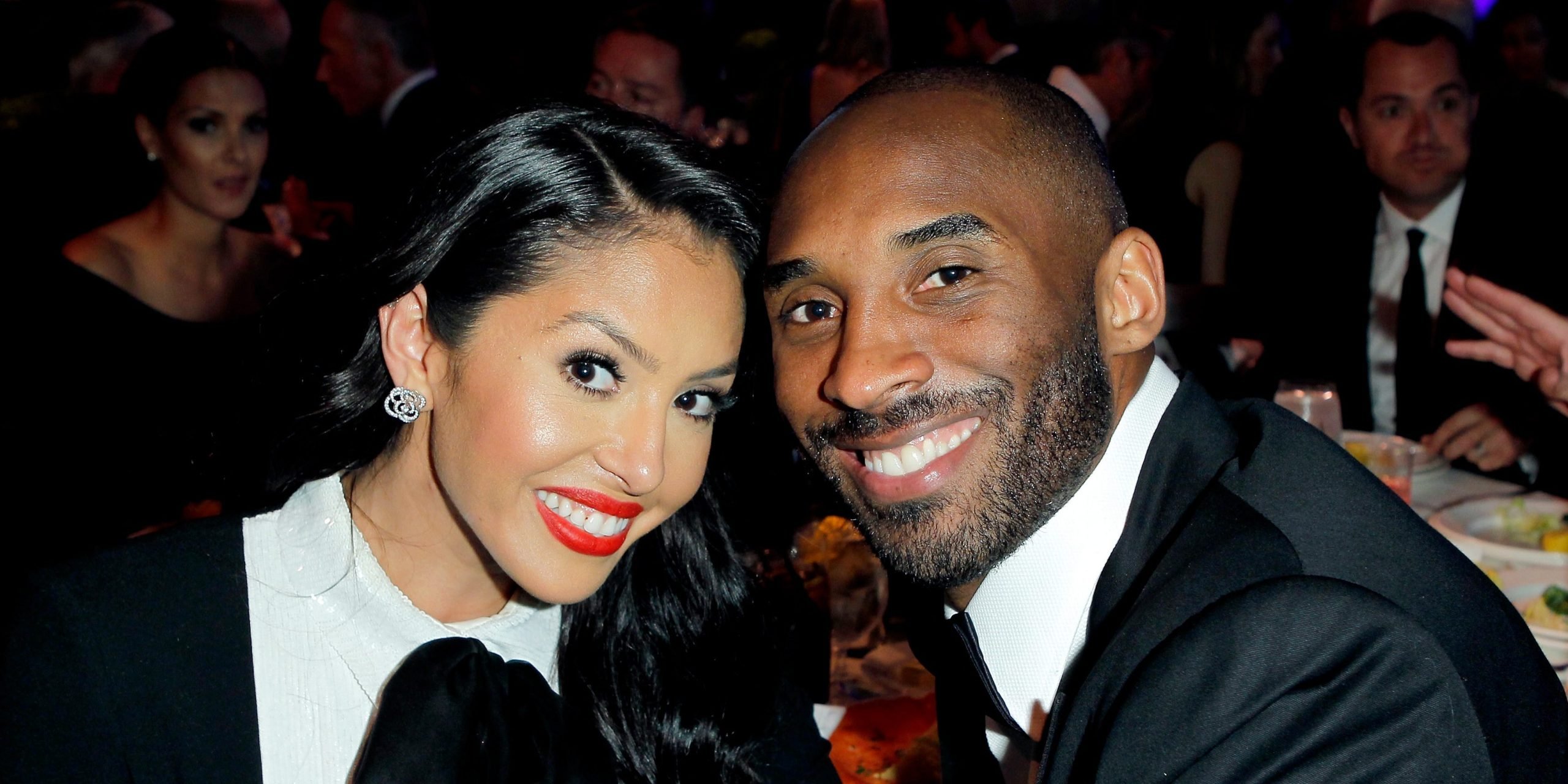 Vanessa Bryant (left) and Kobe Bryant (right) touching heads to pose for a photo in black and white attire