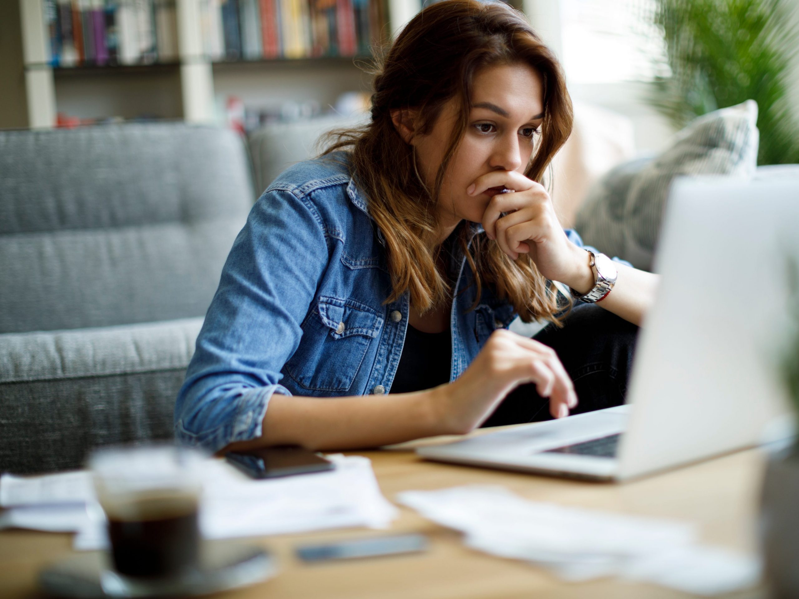 Worried young woman working at home upset work computer laptop