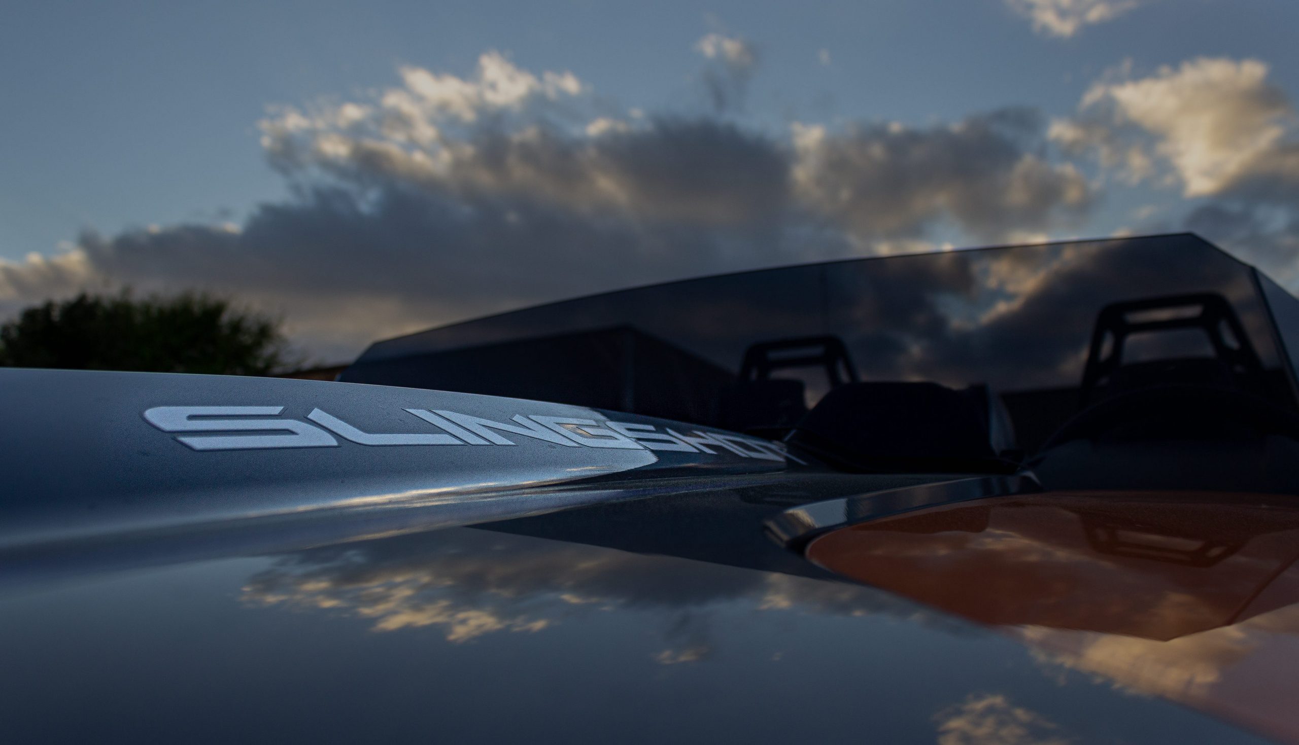 A gray, blue, and orange Polaris Slingshot.