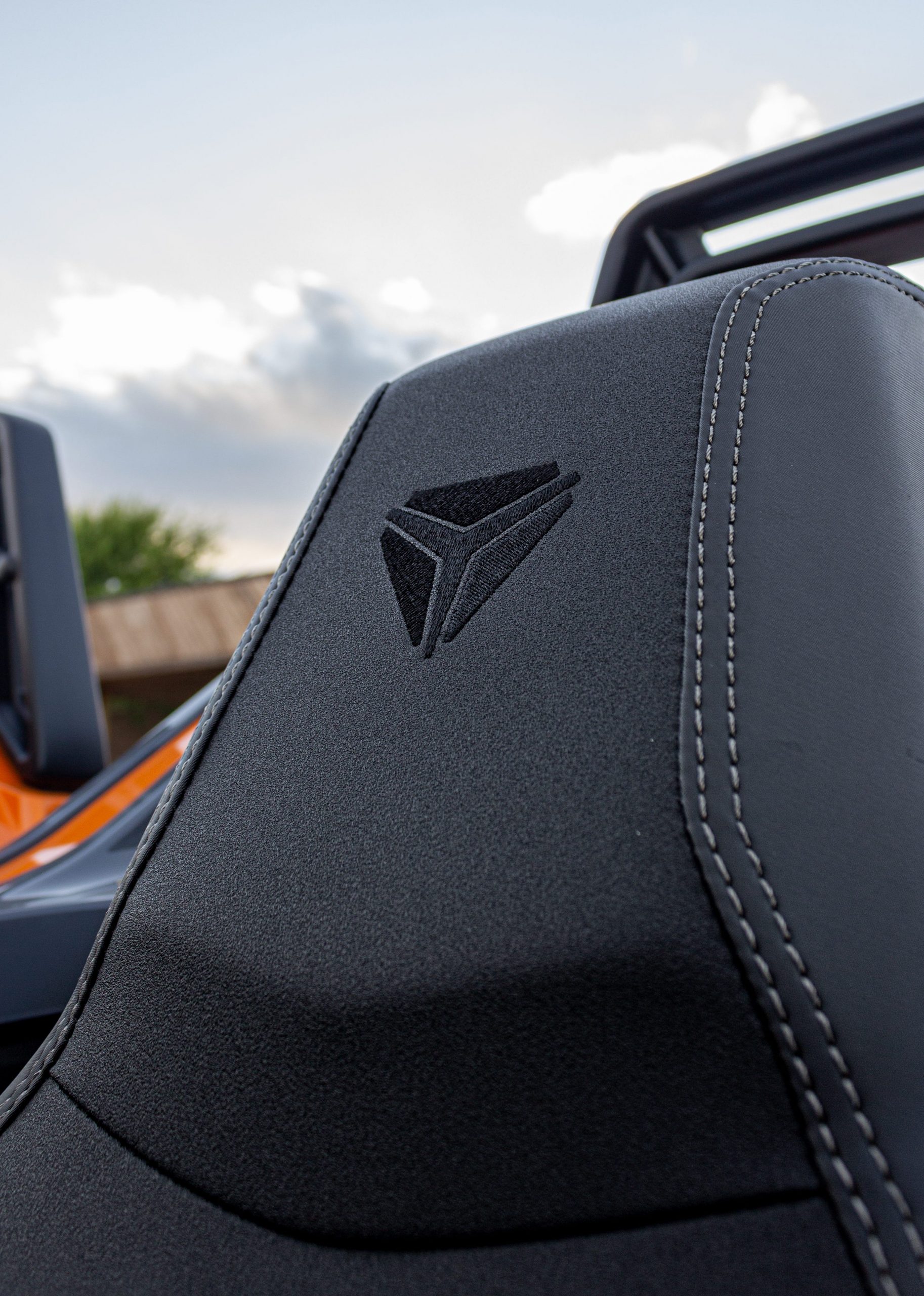 A gray, blue, and orange Polaris Slingshot.