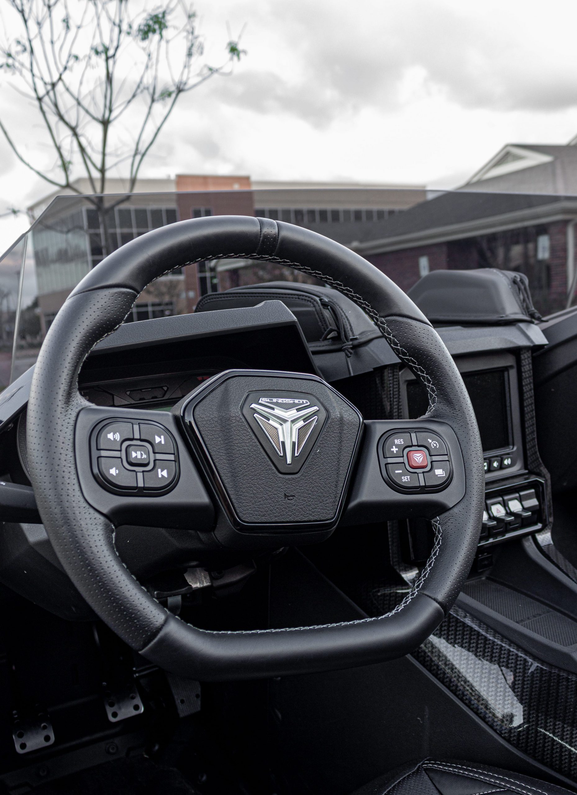 A gray, blue, and orange Polaris Slingshot.