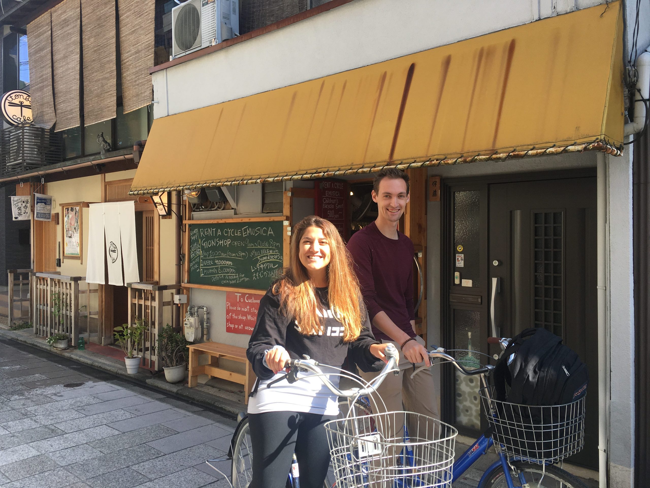 The writer posing with a bike outside of a market
