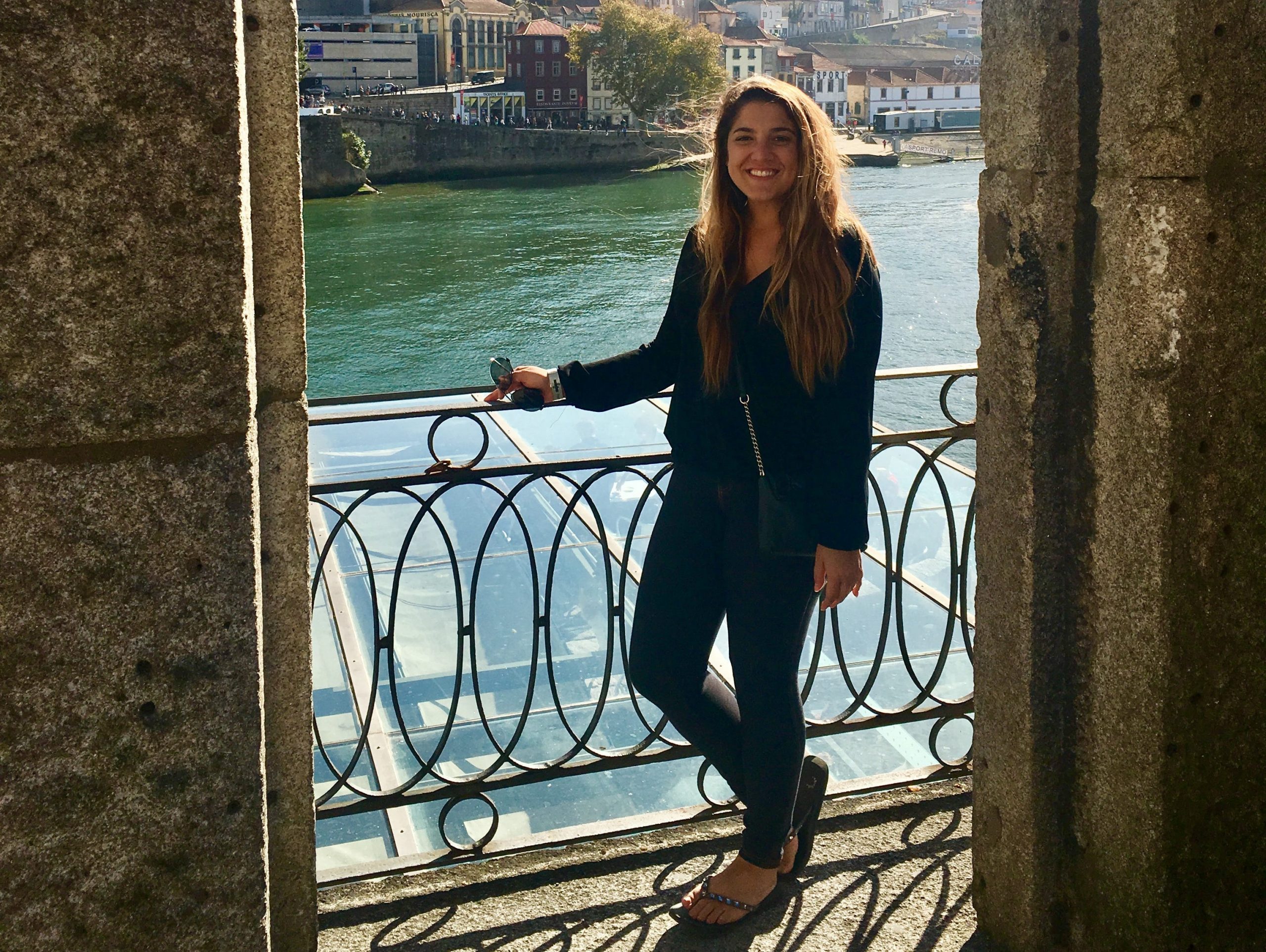The writer wearing jeans posing in front of a view of a city