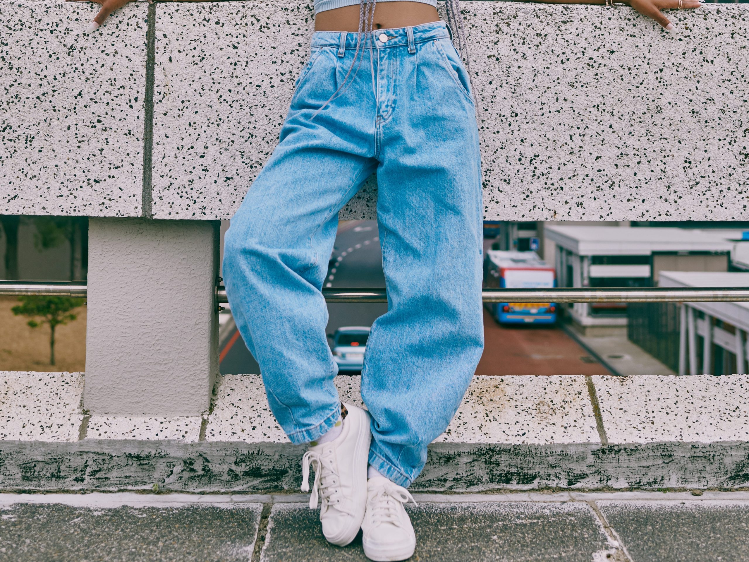 woman wearing loose jeans and a crop top with a bucket hat