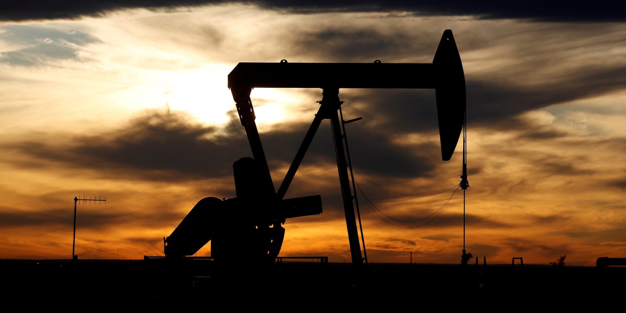 crude oil pump jack in texas field sunset backdrop