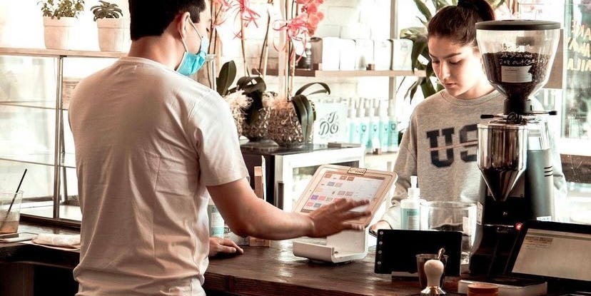 man serving a customer in a coffee shop