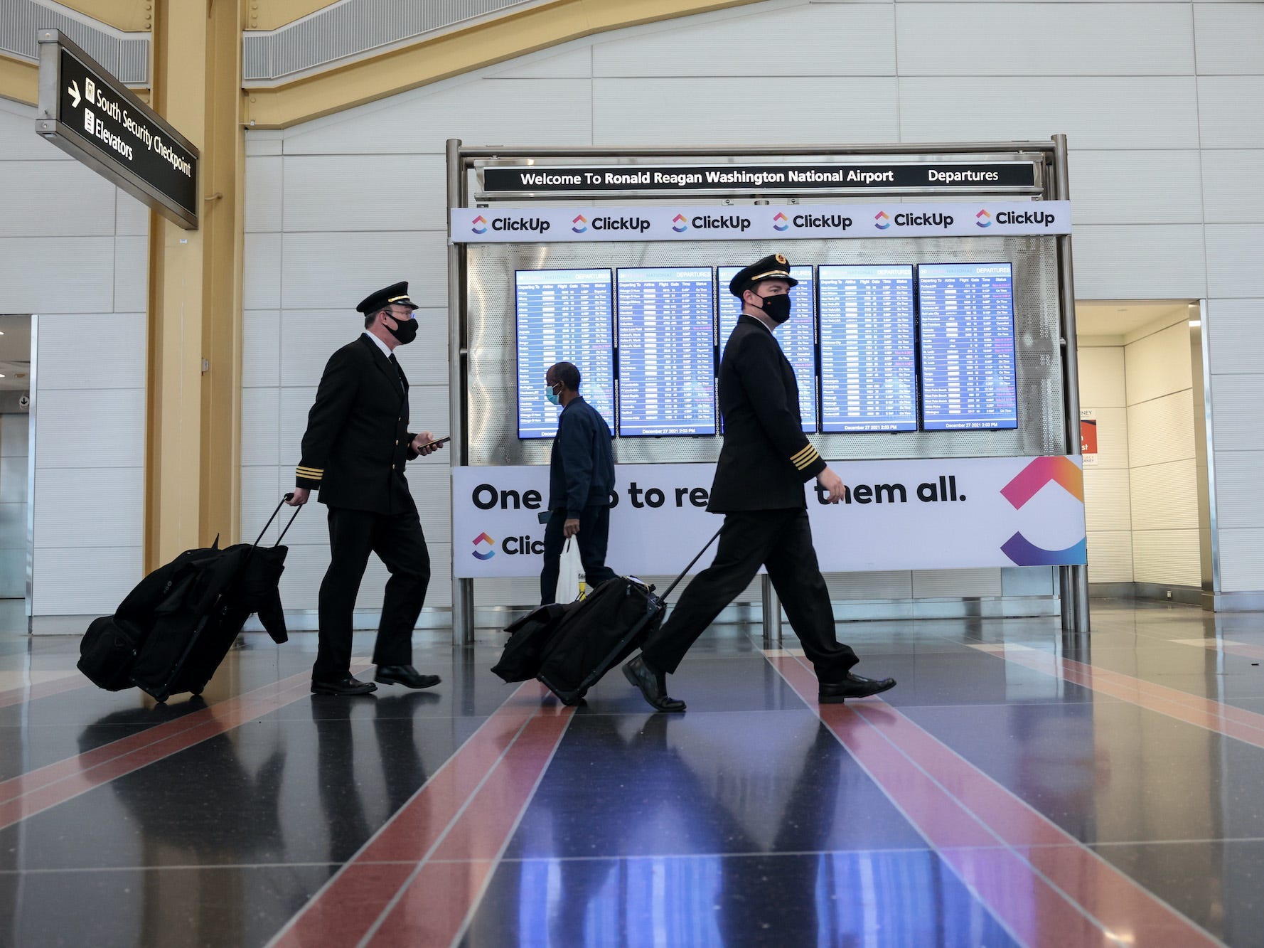 Airplane pilots walk through an airport.