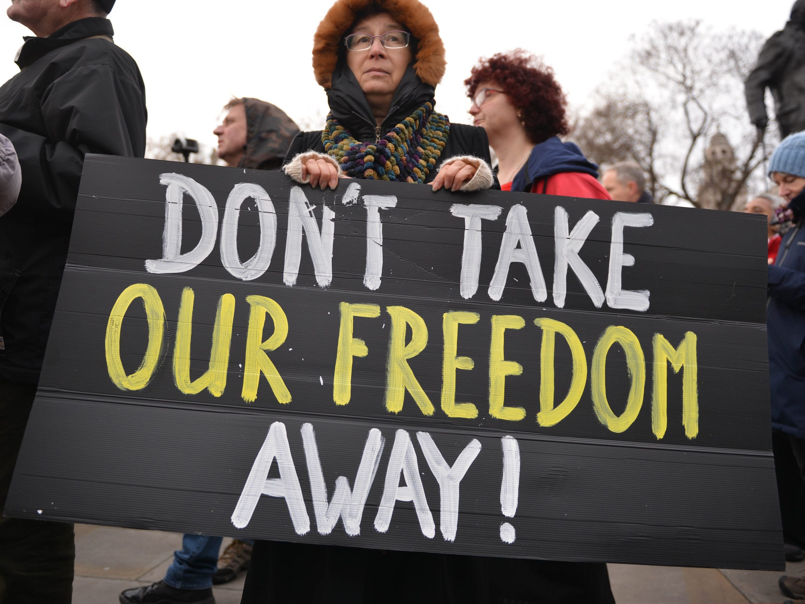 A protester holds a 'Don't Take Our Freedom Away' placard