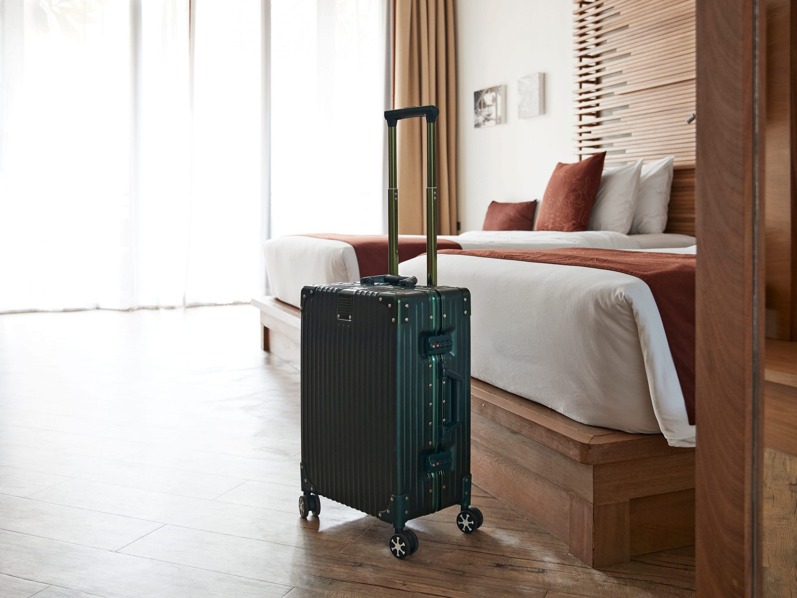 A suitcase by two beds in a hotel room