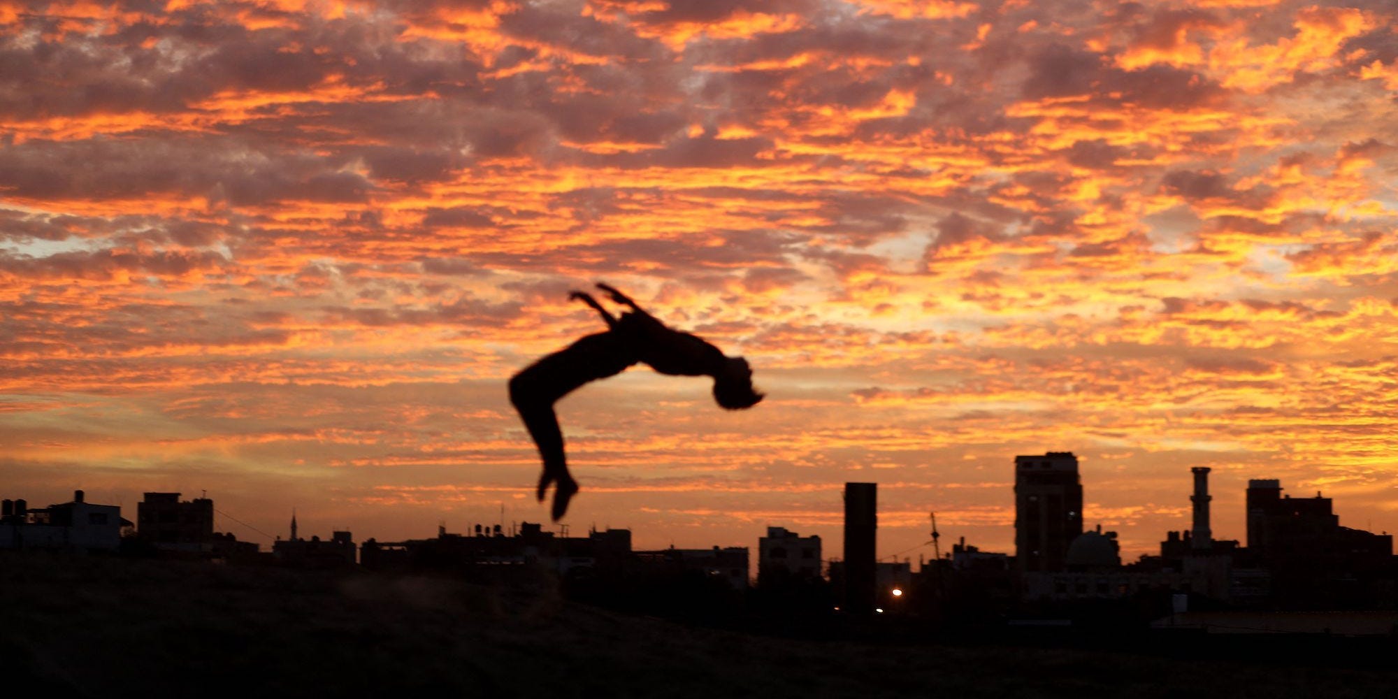 A Palestinian practises parkour during sunset in Rafah in the southern Gaza Strip on December 4, 2021