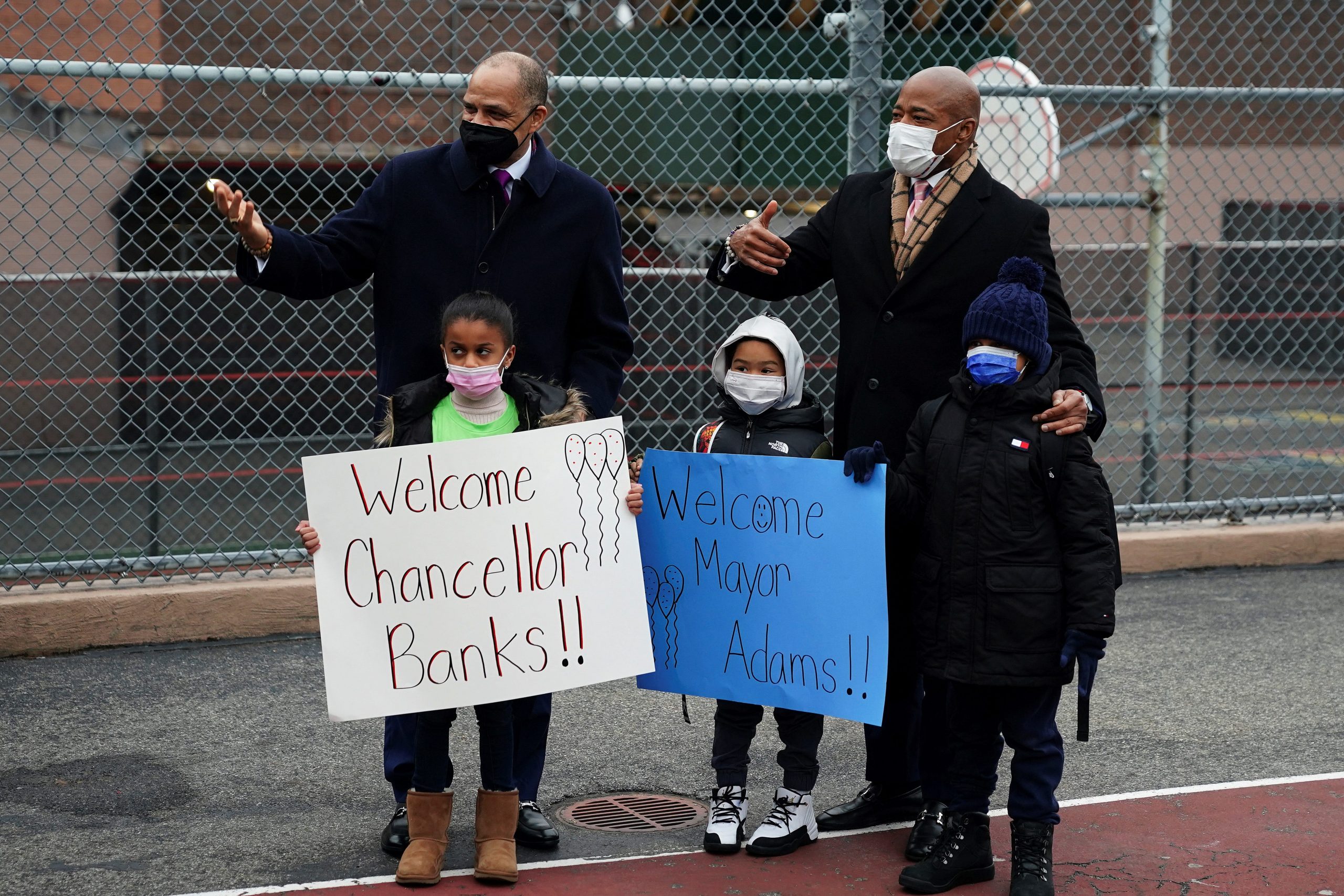 two adults and 3 children holding welcome signs