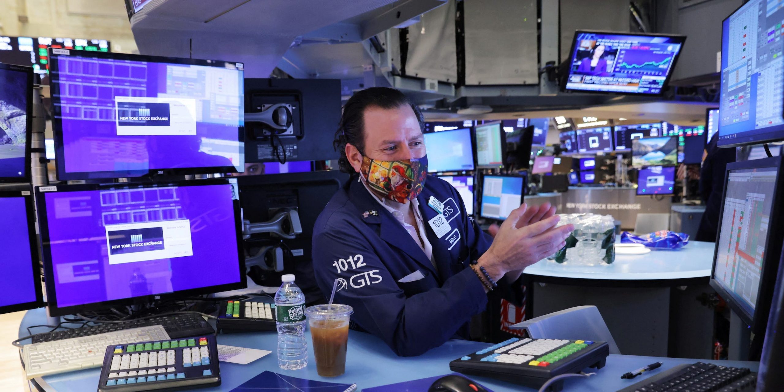 Trader with screens on NYSE floor clapping