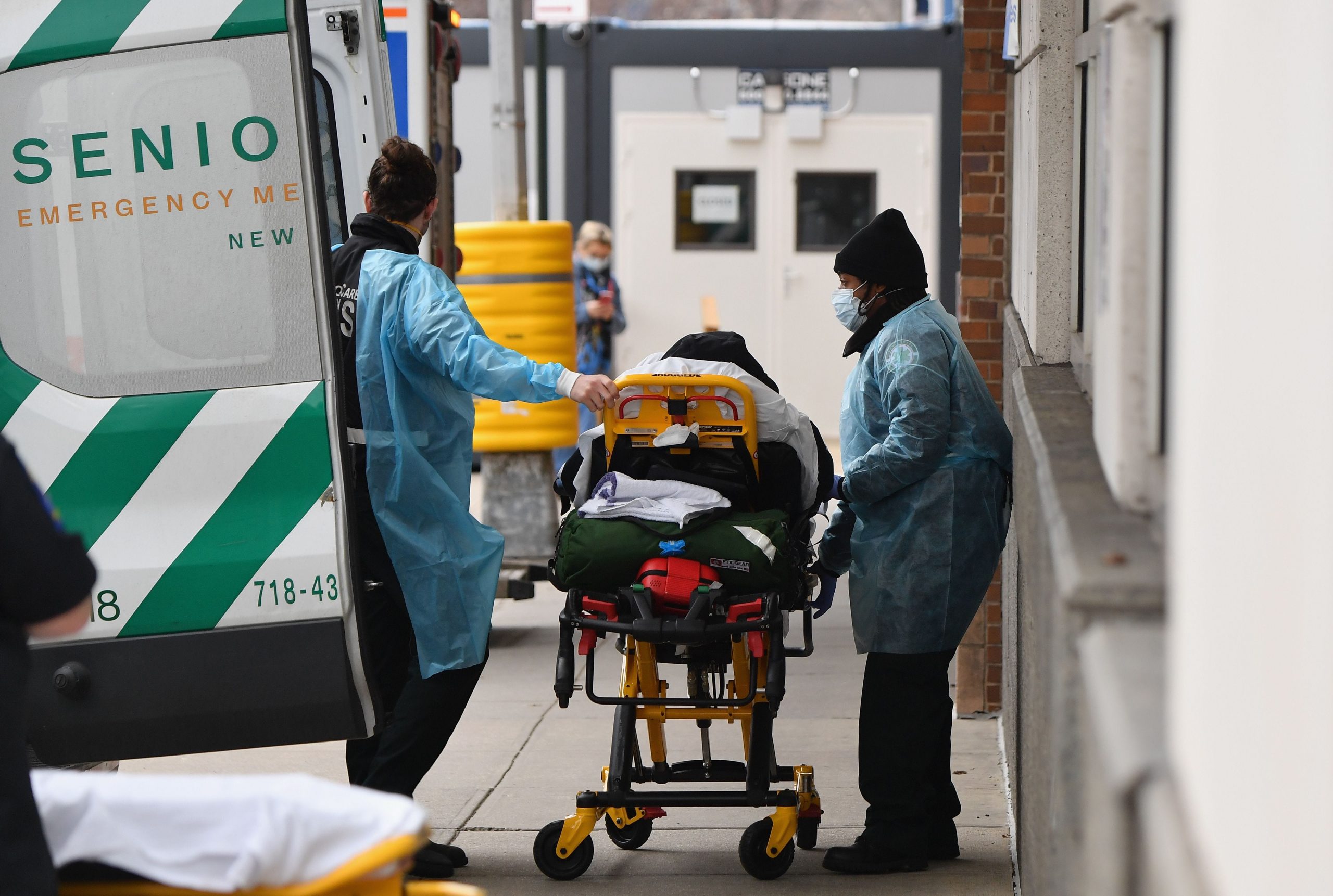 A patient on trolley is transferred from ambulance to hospital.