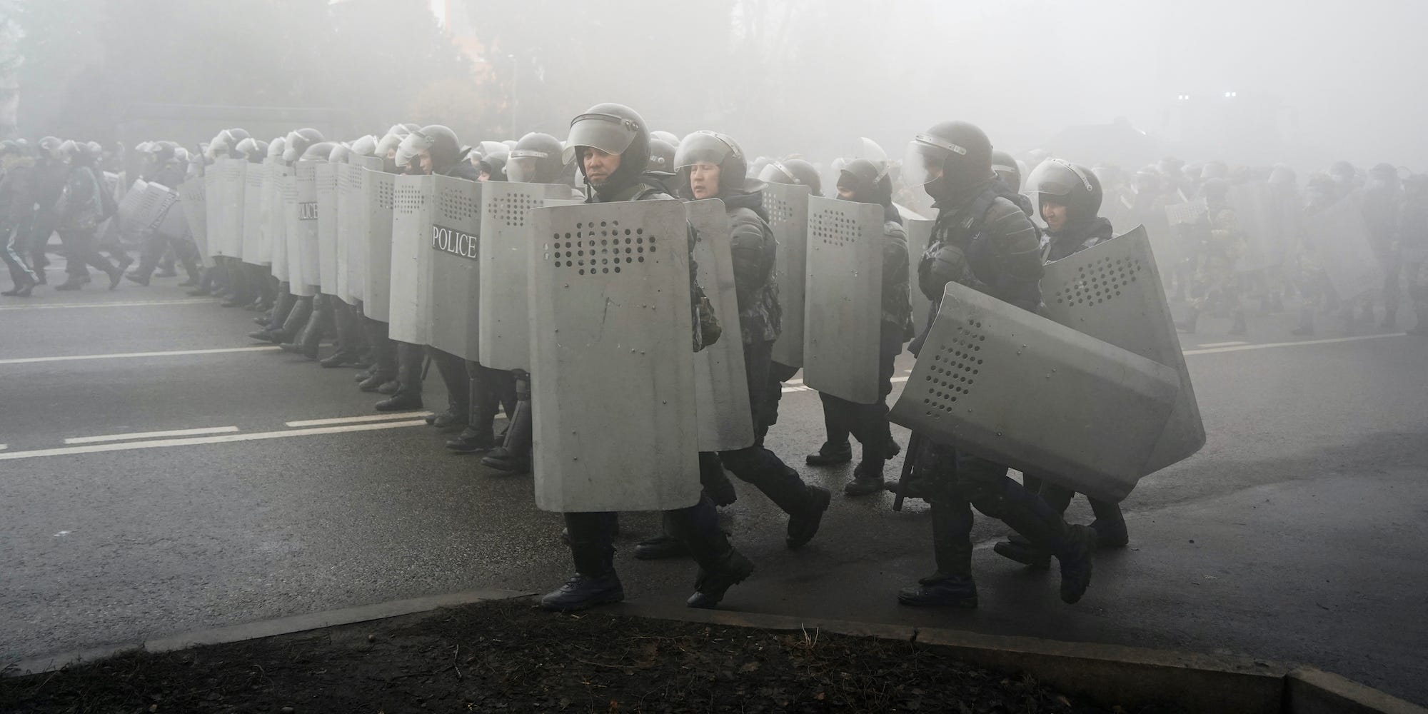Riot police walk in smoke in Kazakhstan