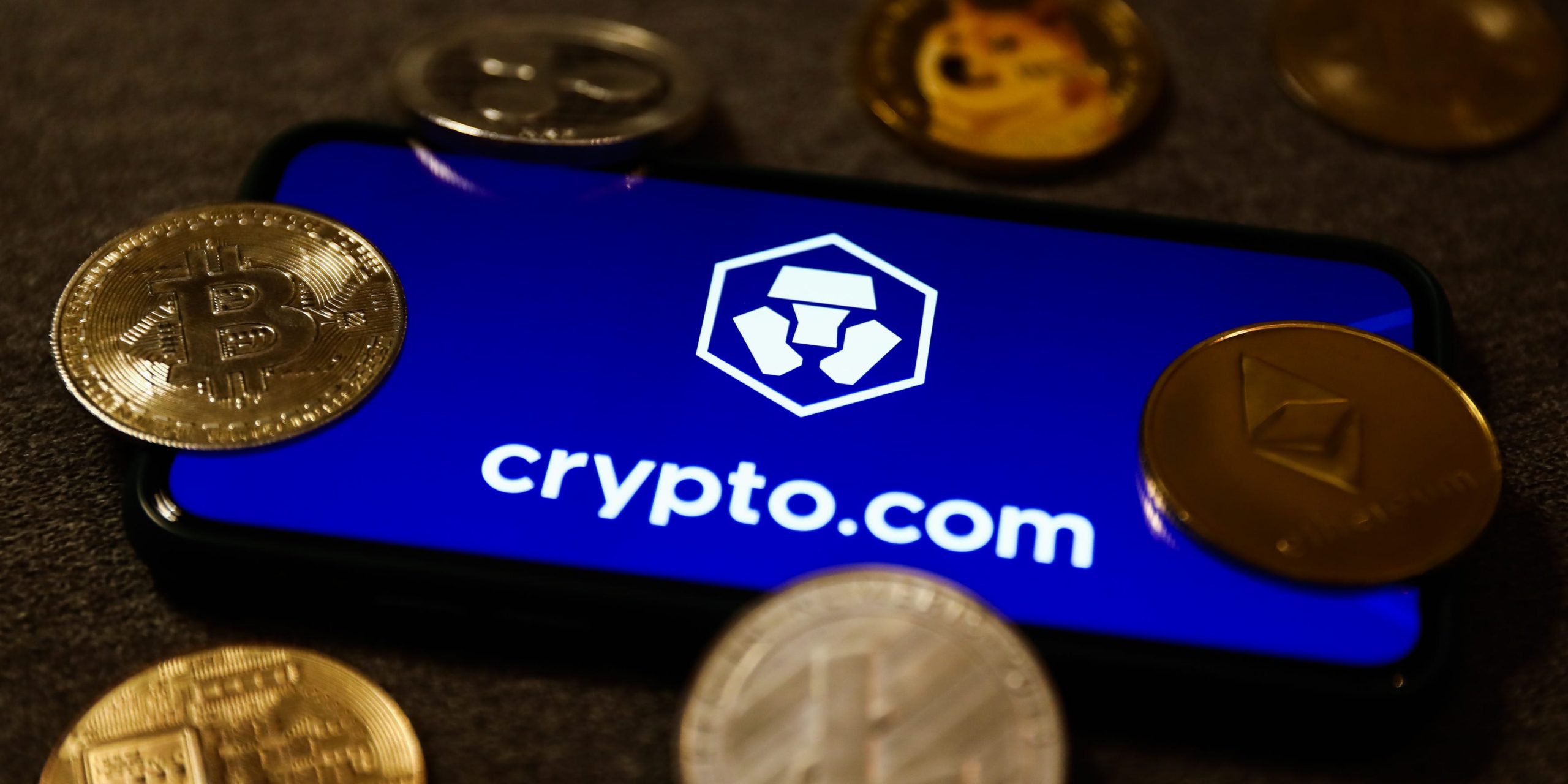 Crypto.com logo displayed on a phone screen and representation of cryptocurrencies are seen in this illustration photo taken in Krakow, Poland on September 28, 2021.