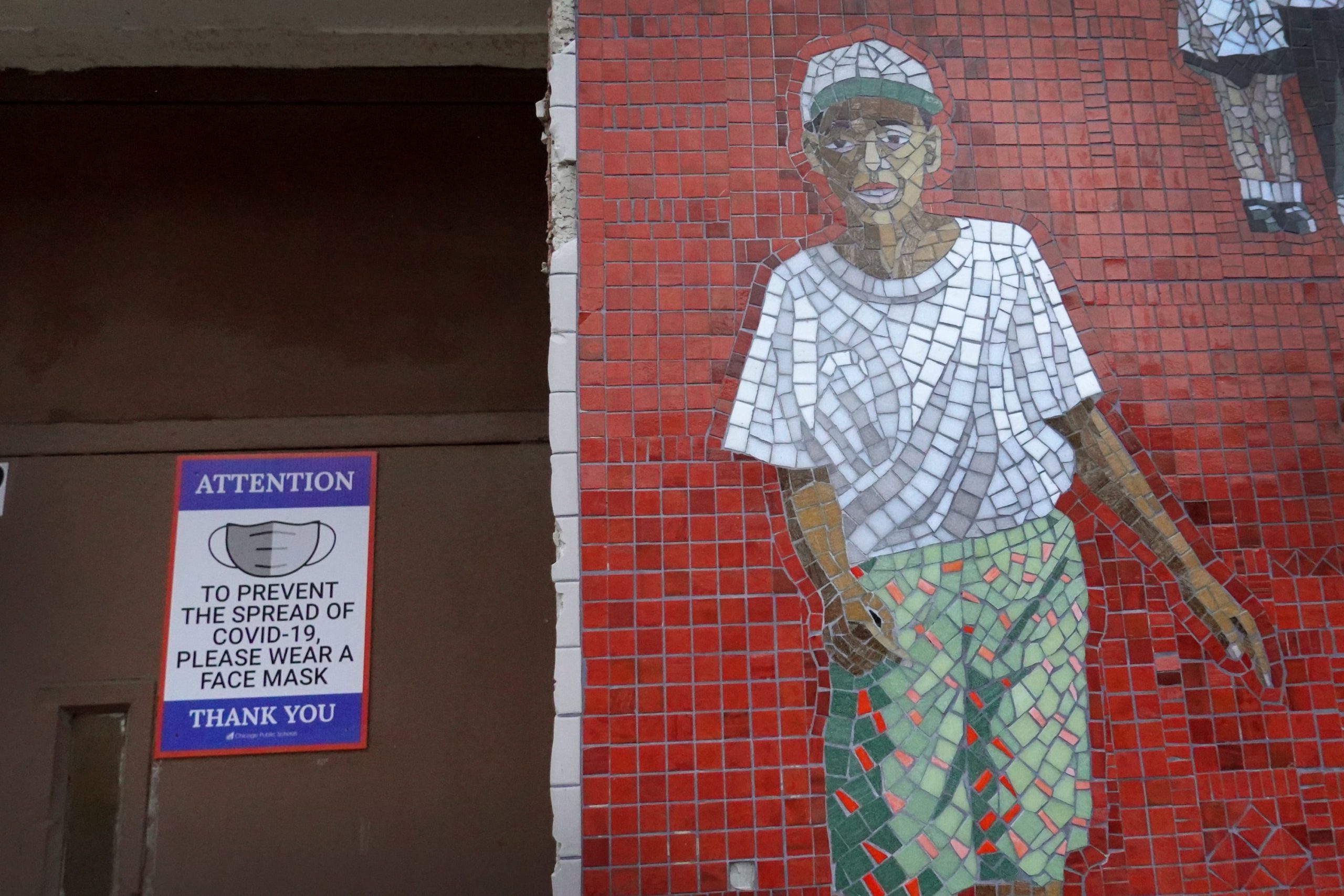 Chicago public school building with COVID sign and mosaic tile in shape of boy