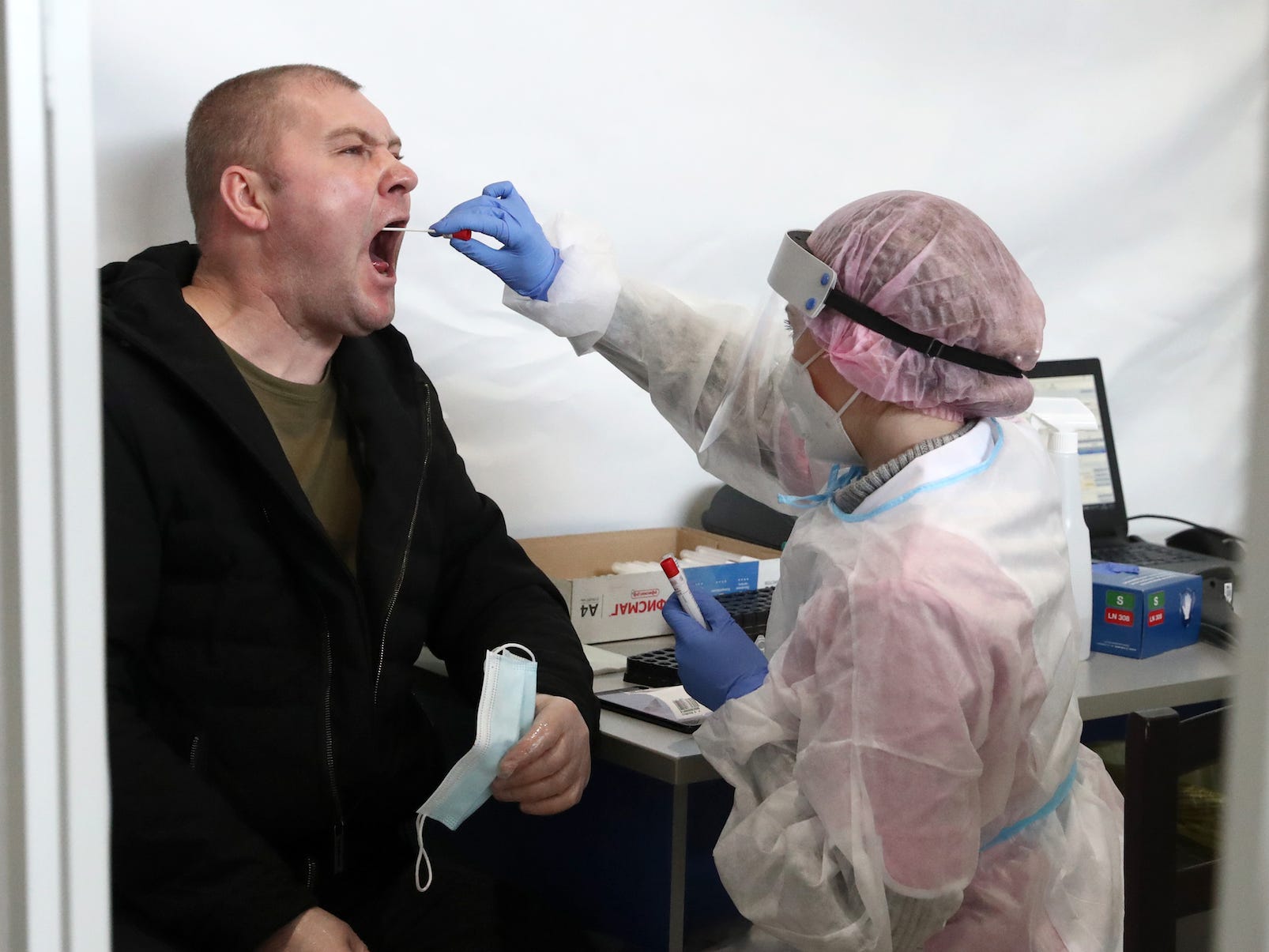 man opening wide for saliva swab