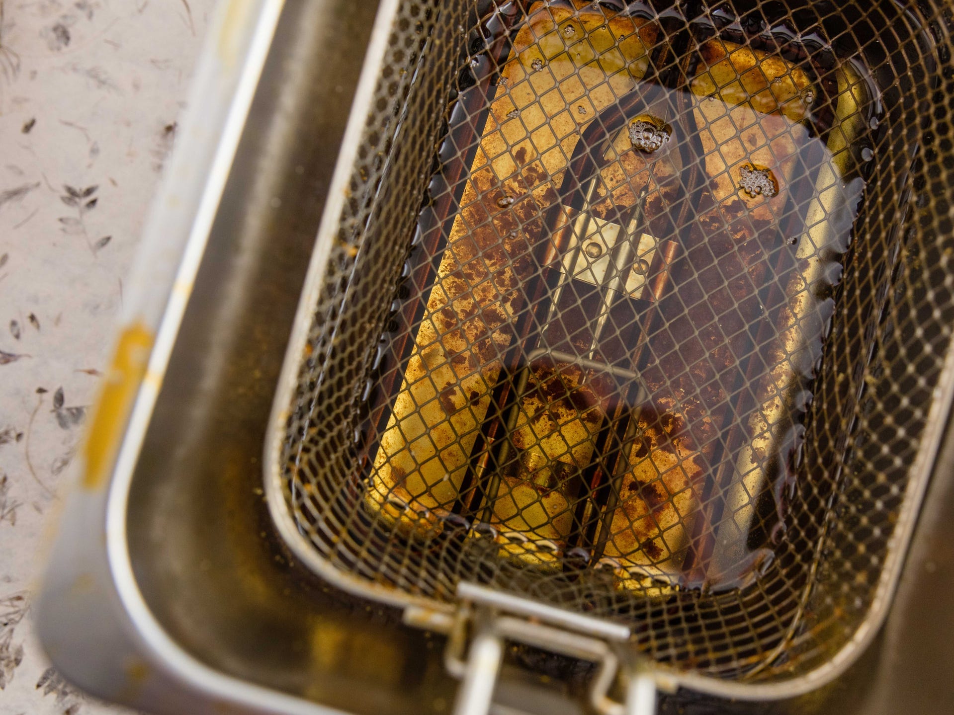 A view from above of dirty oil in a deep fryer