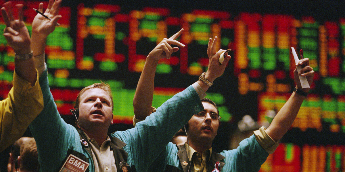 A photo of traders waving their arms on the floor of the New York Stock Exchange.