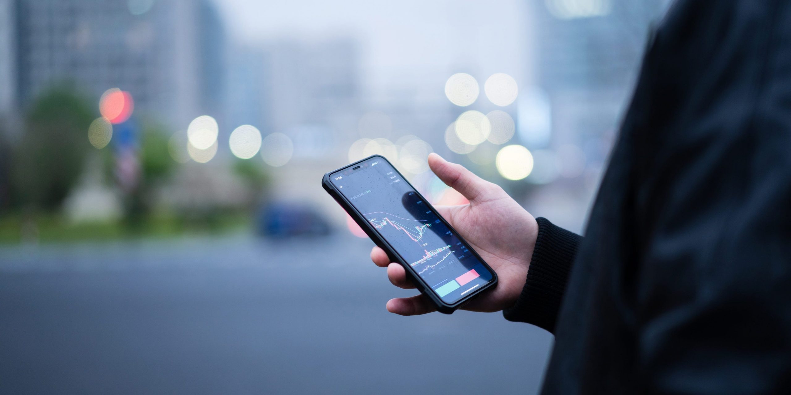 A person looks at a graph of the stock market on their phone.