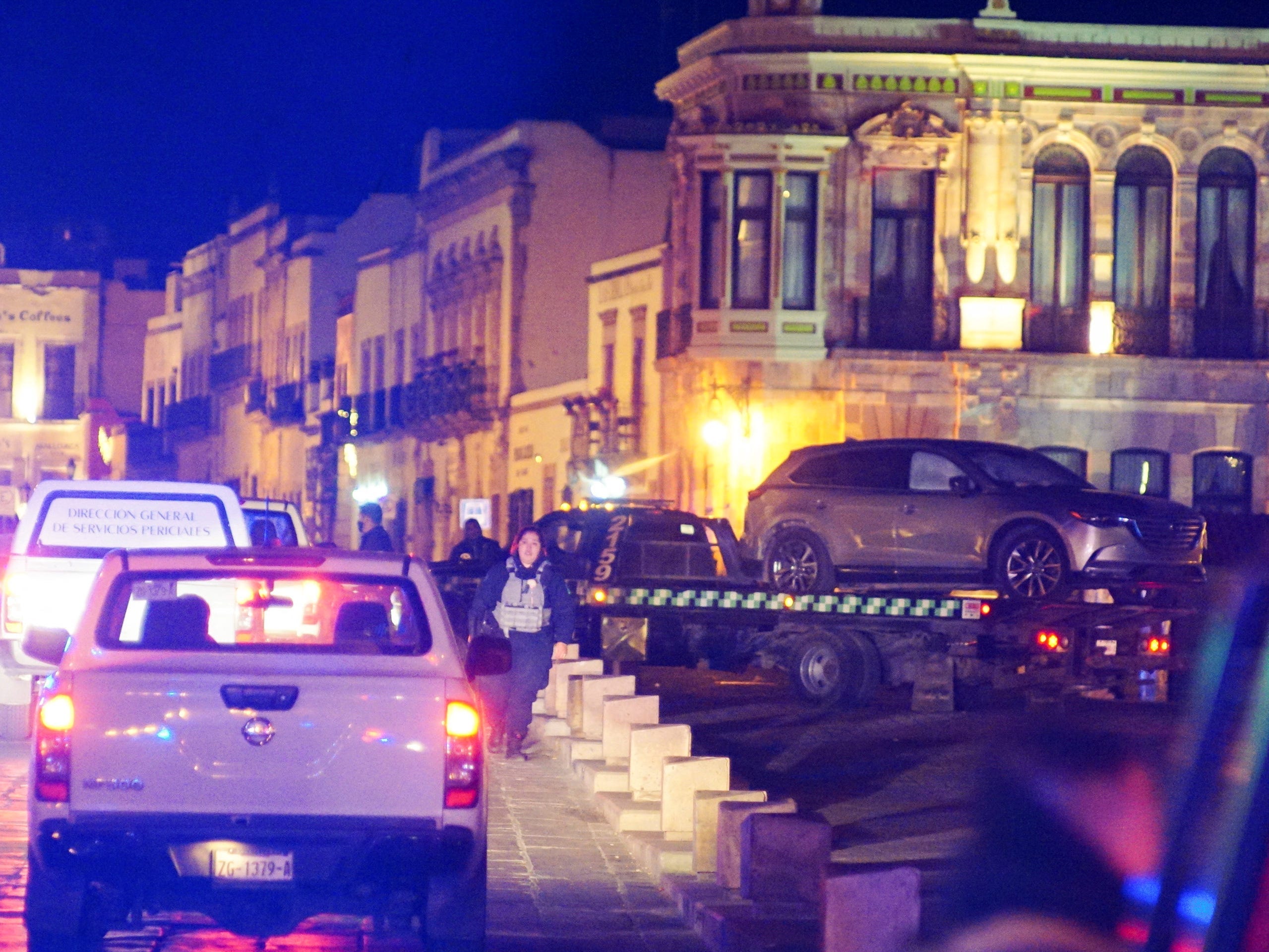 Police forces work at the scene as they remove a vehicle with bodies that were left by unknown assailants in front of the Government Palace, in Zacatecas, Mexico.