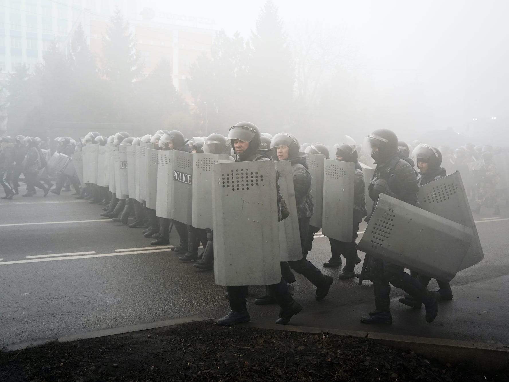 Riot police walk in smoke in Kazakhstan