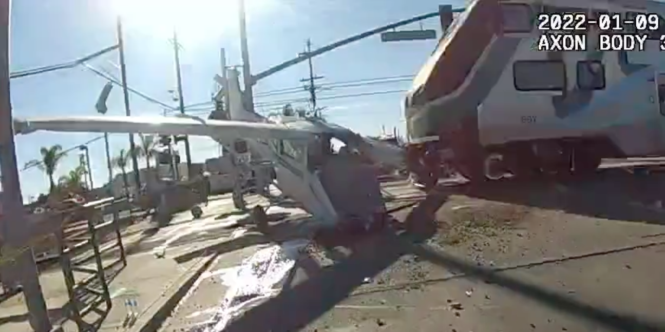A small plane on train tracks, with the train just about to hit into it
