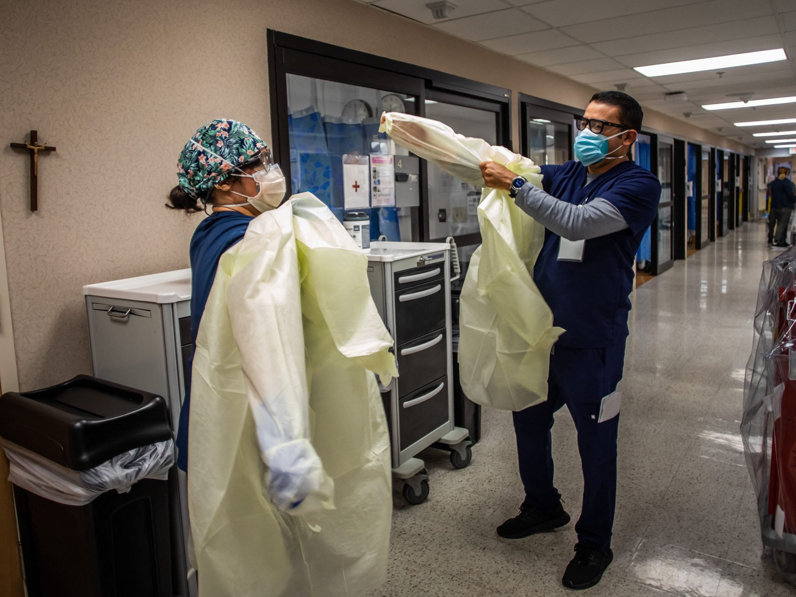 Two intensive care nurses put on personal protective equipment outside an Cardiovascular Intensive Care Unit