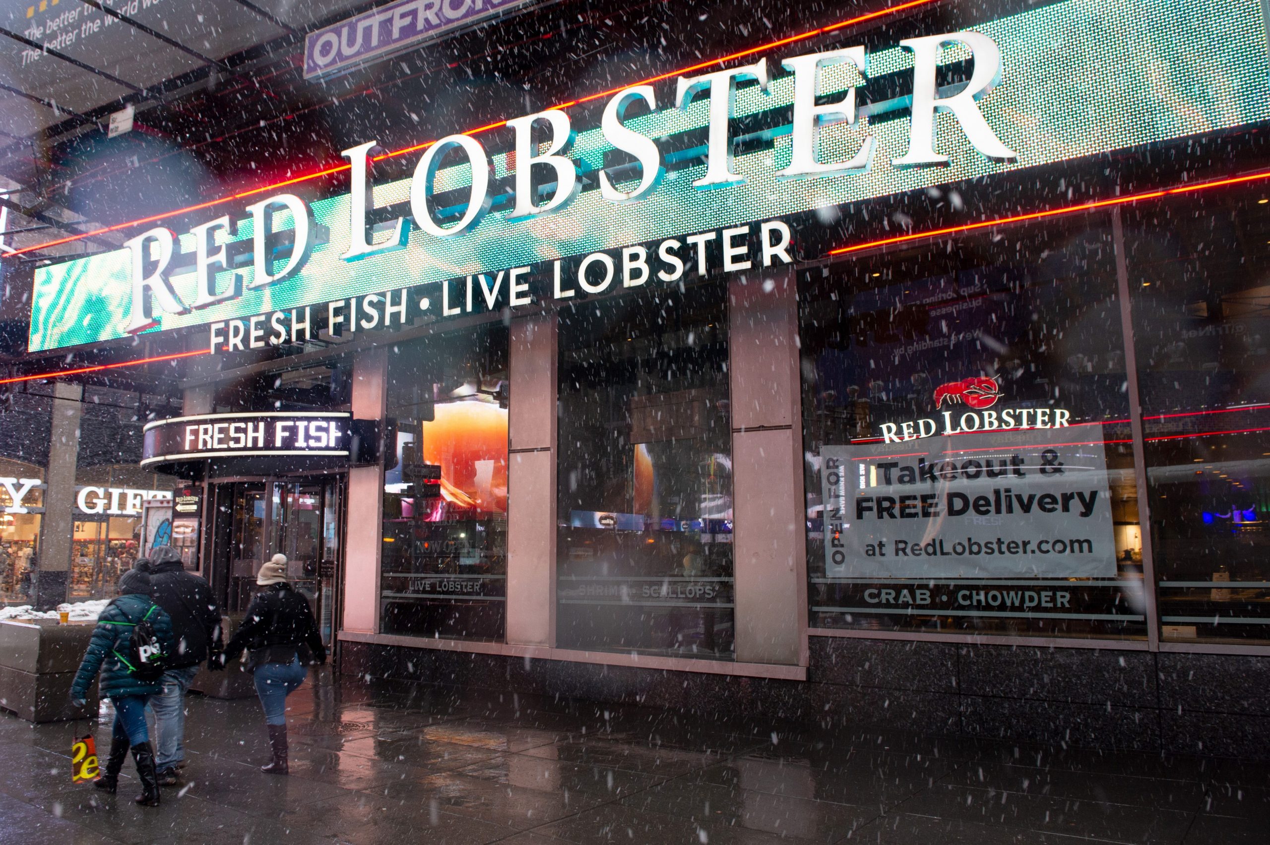 A "takeout and Free delivery" sign is displayed in the window of Red Lobster in Times Square during a snow storm on February 07, 2021 in New York City.